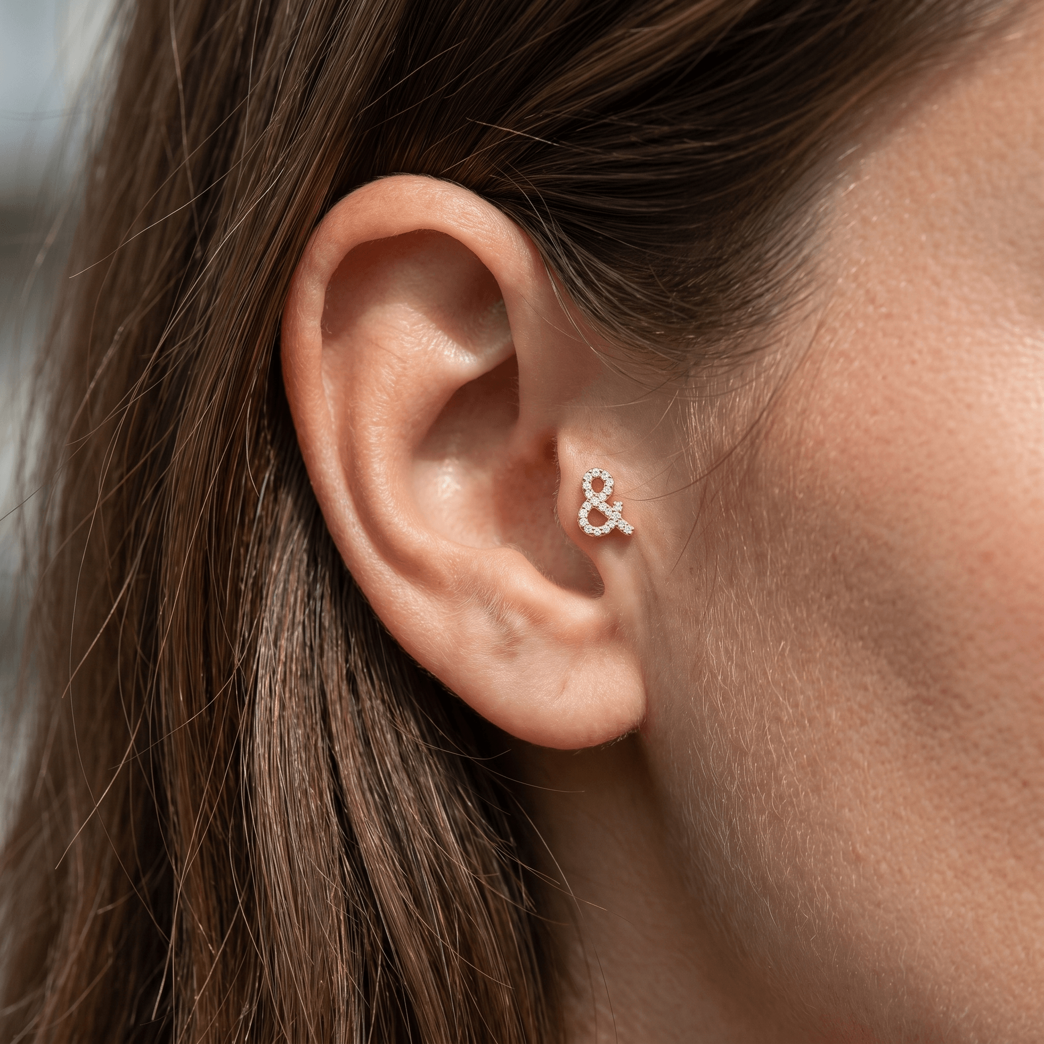 Gold ampersand zircon stud — tragus jewelry placement