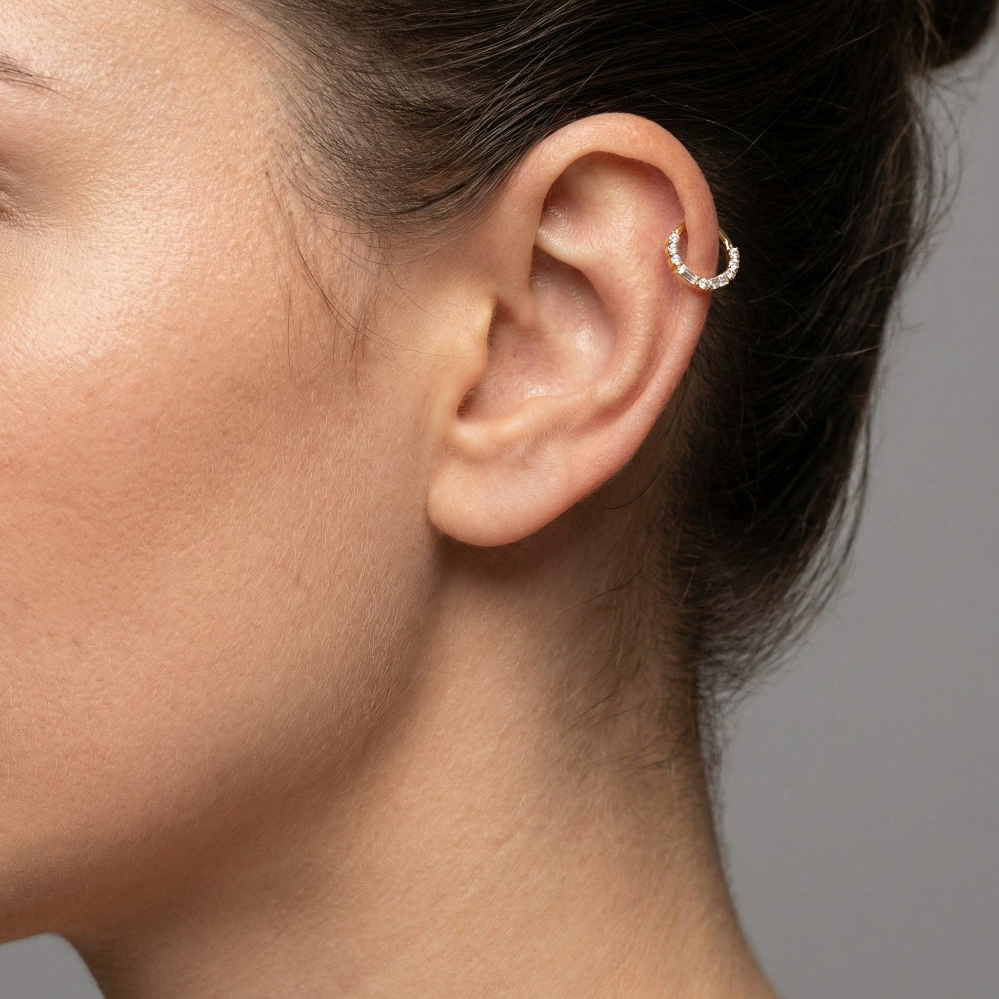 Model displaying a silver baguette and round zircon hinged clicker hoop perfectly