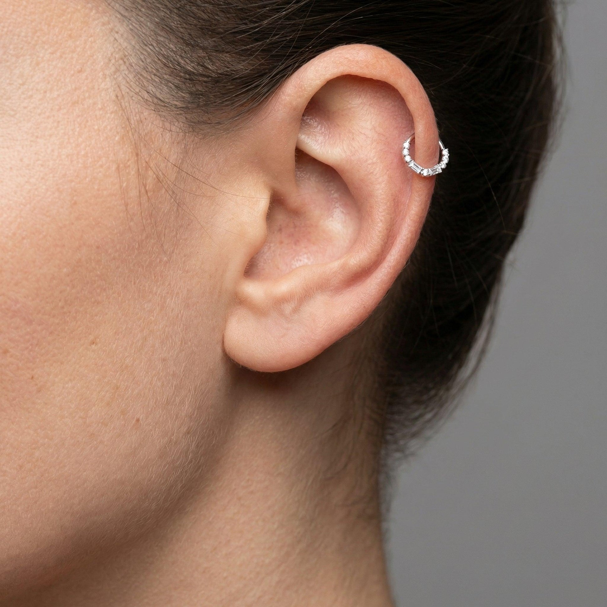 Model displaying a silver baguette and round zircon hinged clicker hoop perfectly