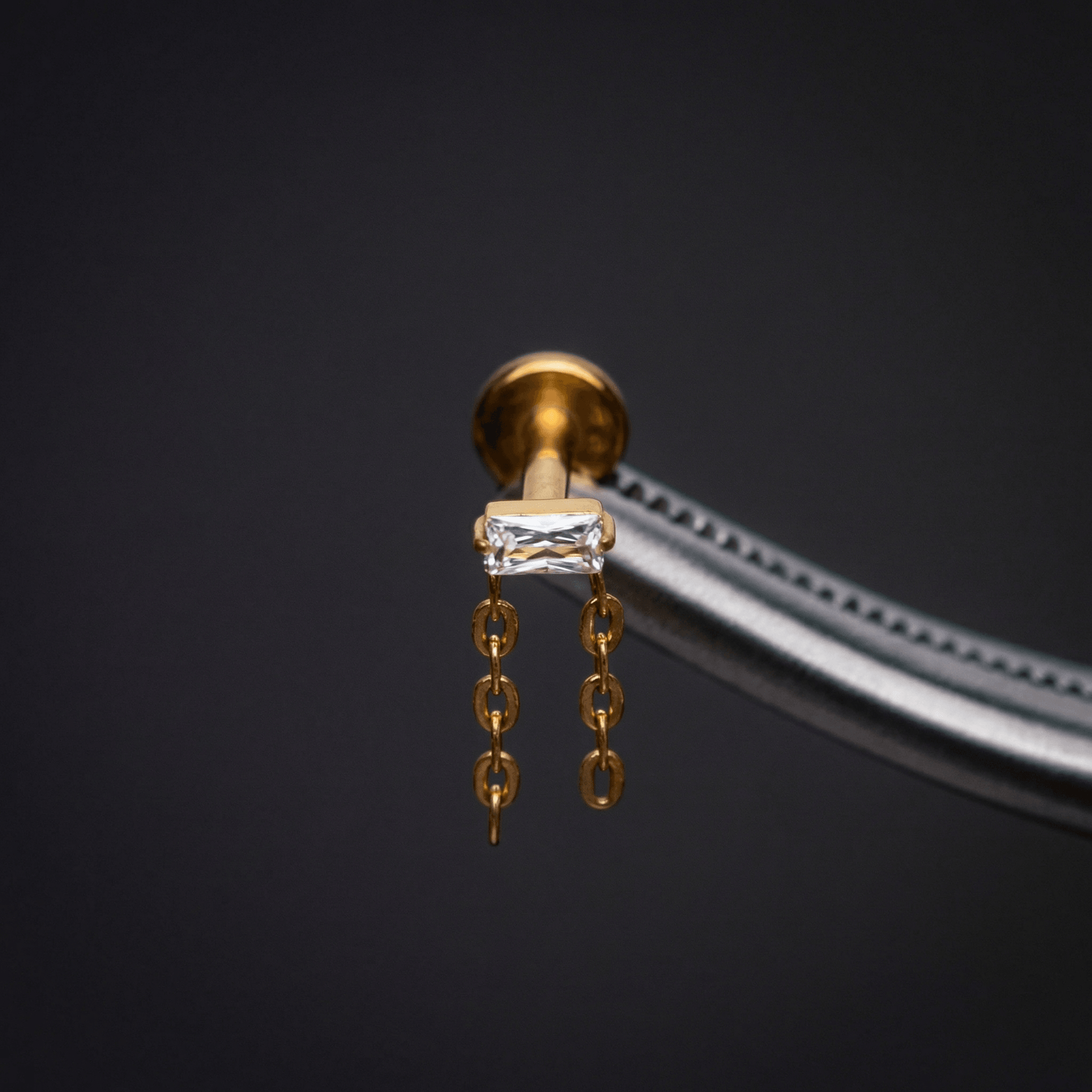 Baguette Hidden Helix Piercing - Tweezers holding a gold
