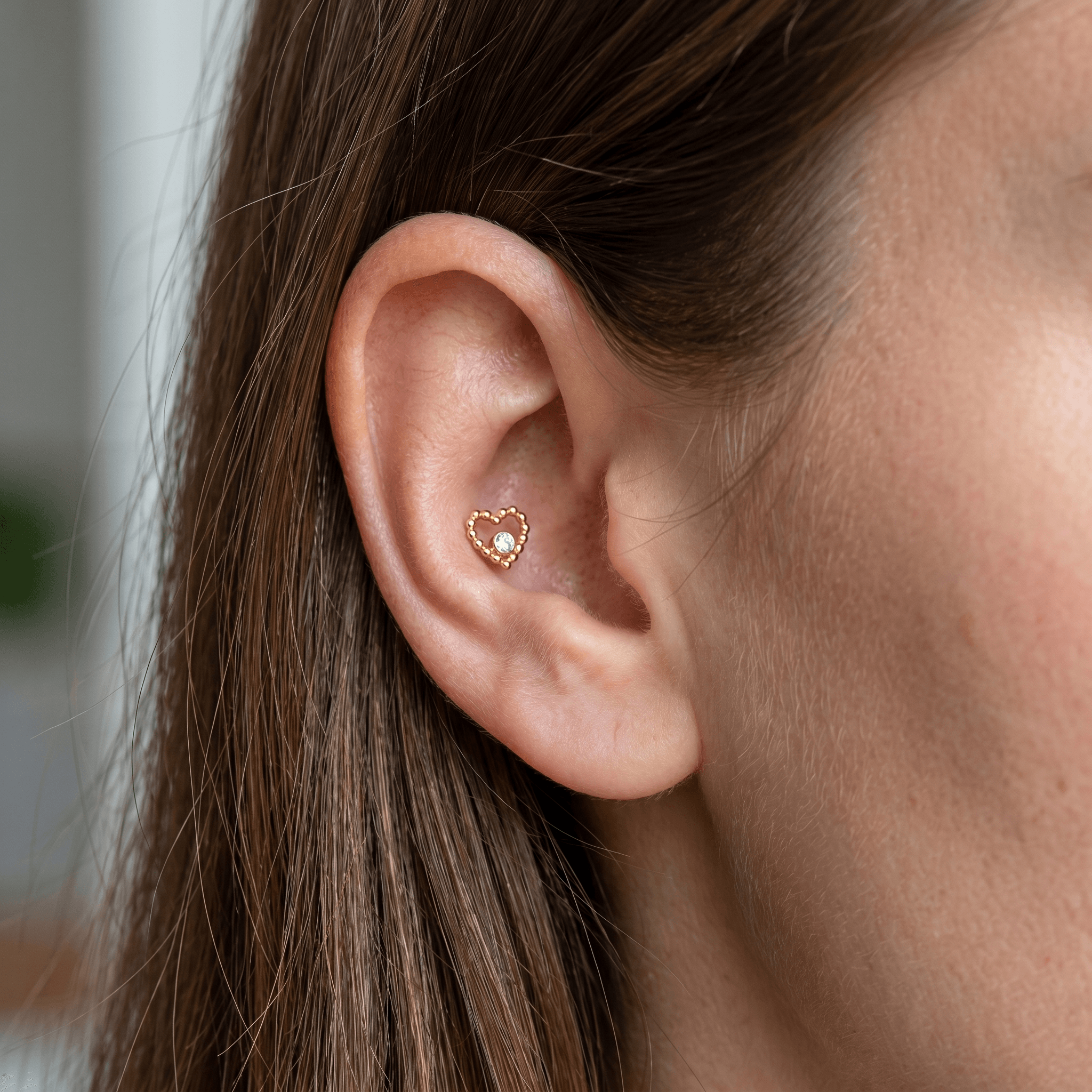 Gold titanium beaded heart piercing stud worn securely in an placement.