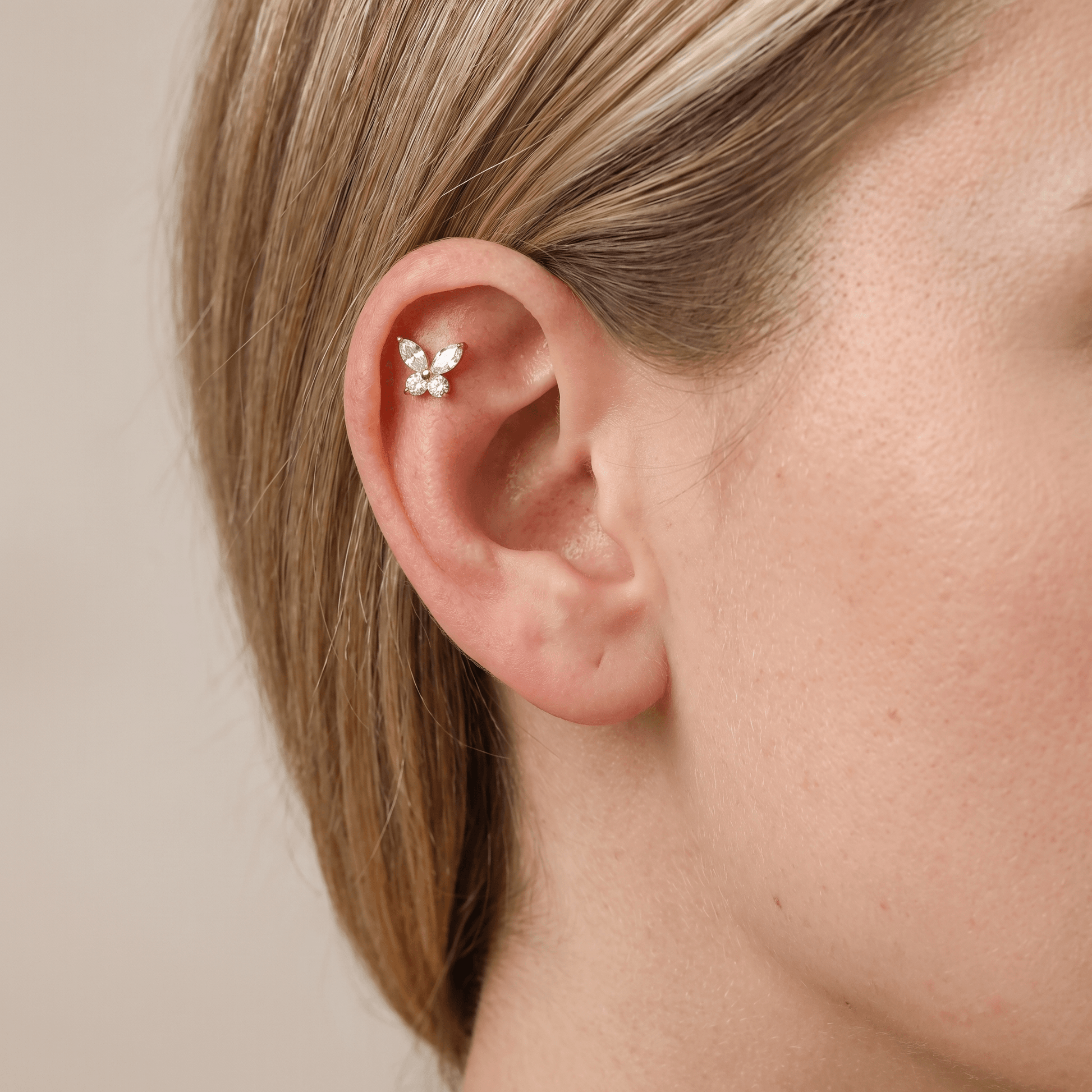 Gold titanium butterfly piercing stud with cubic zirconia worn in a female