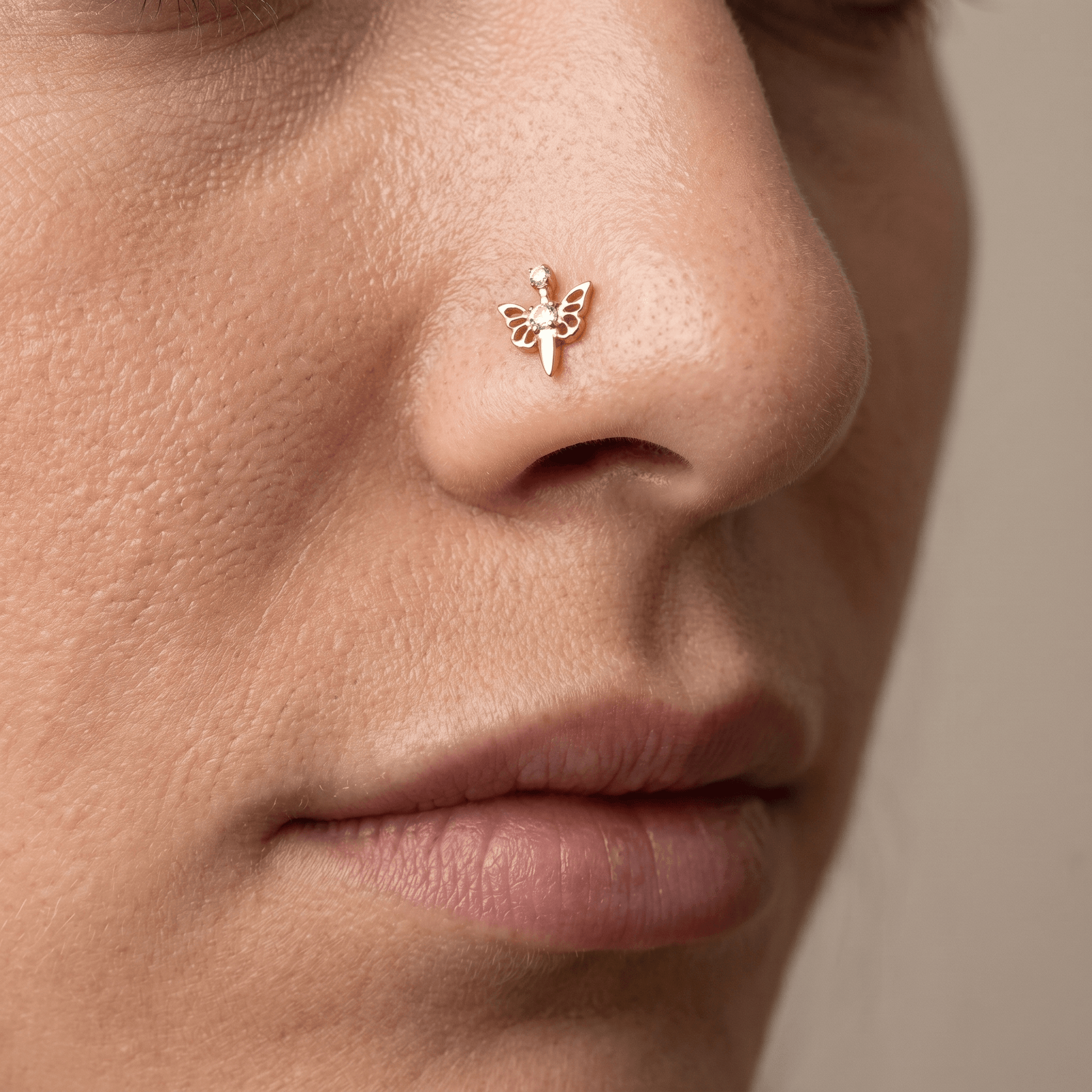 Gold titanium butterfly zircon piercing stud worn beautifully in a female piercing.
