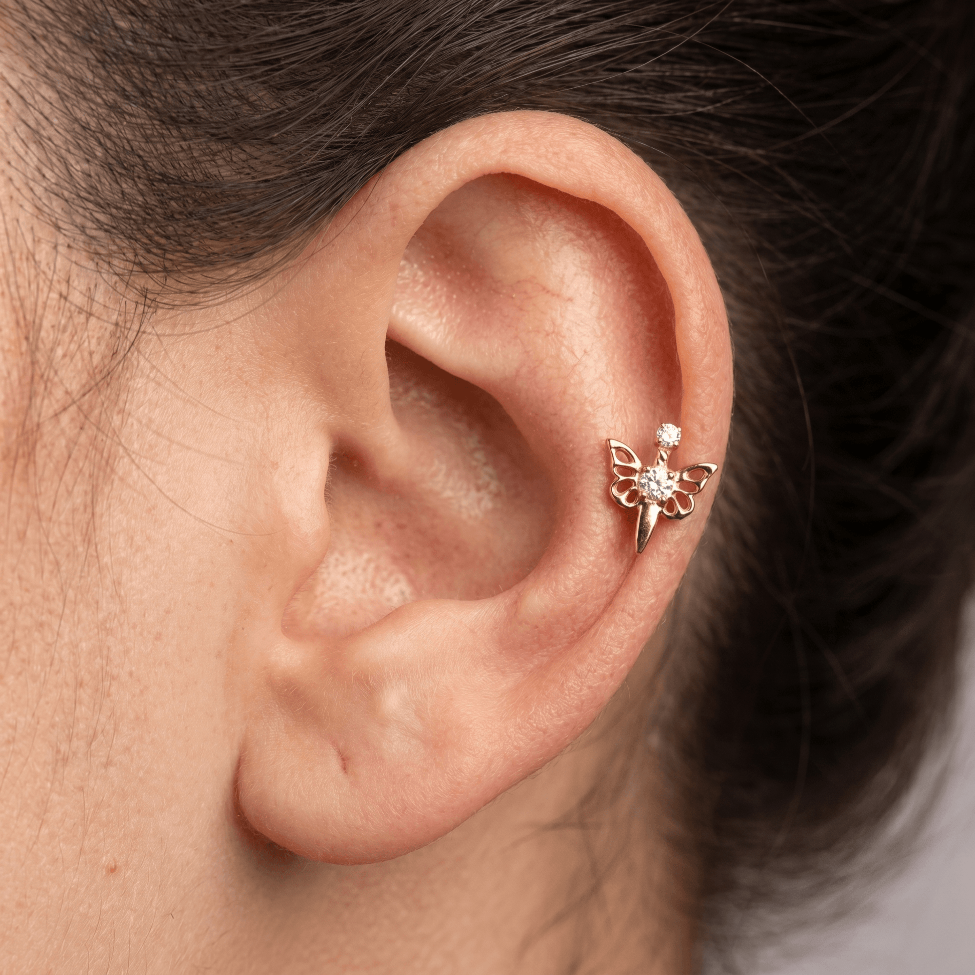 Gold titanium butterfly zircon piercing stud worn perfectly in a female piercing.