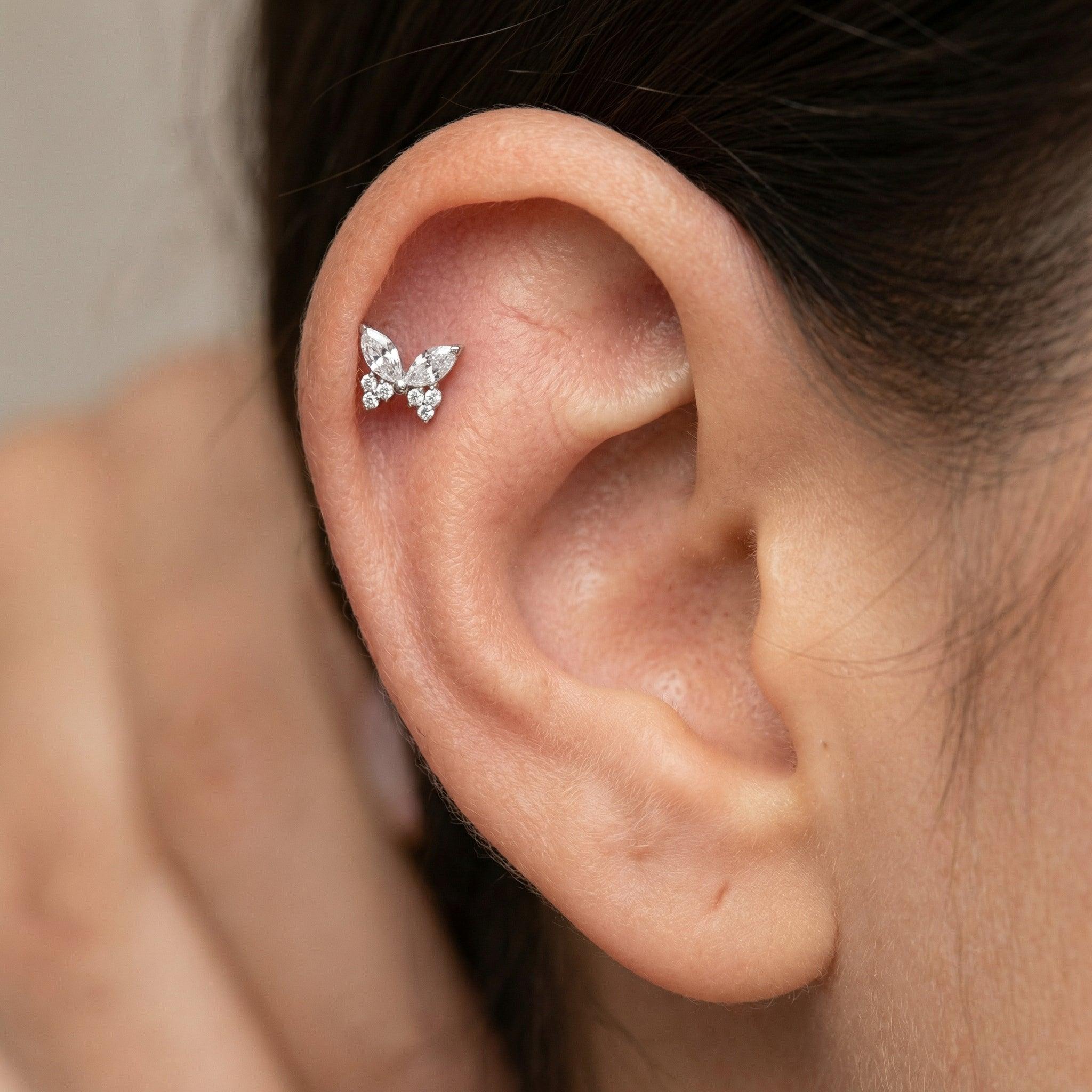 Silver titanium butterfly zircon piercing stud worn in a female .