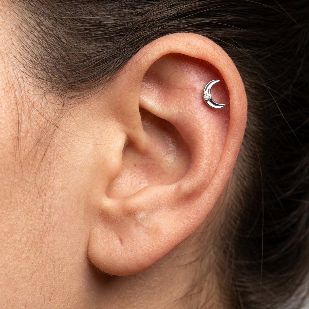 Silver titanium crescent moon piercing stud worn elegantly in a female piercing.
