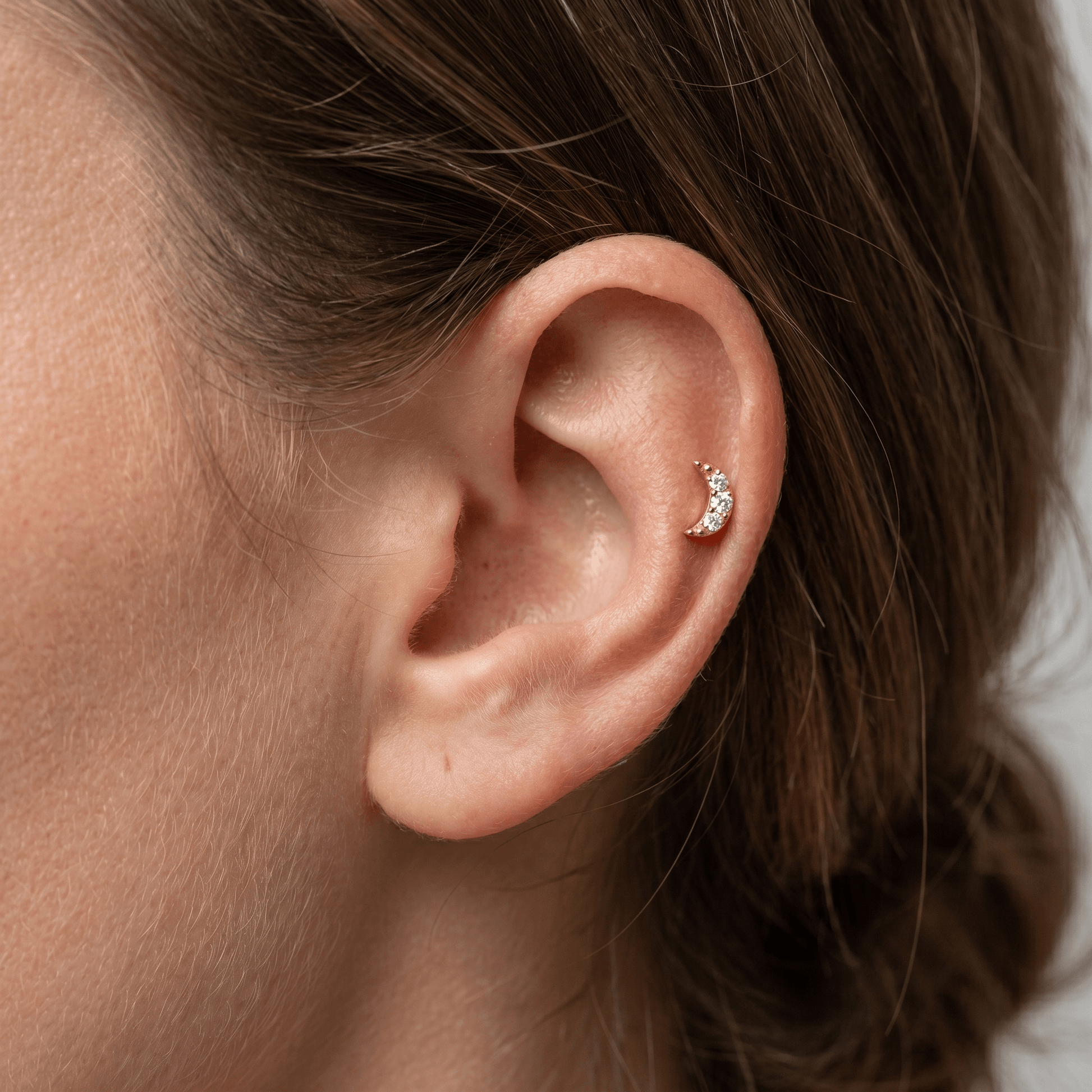Gold titanium crescent moon zircon piercing stud worn elegantly in a female