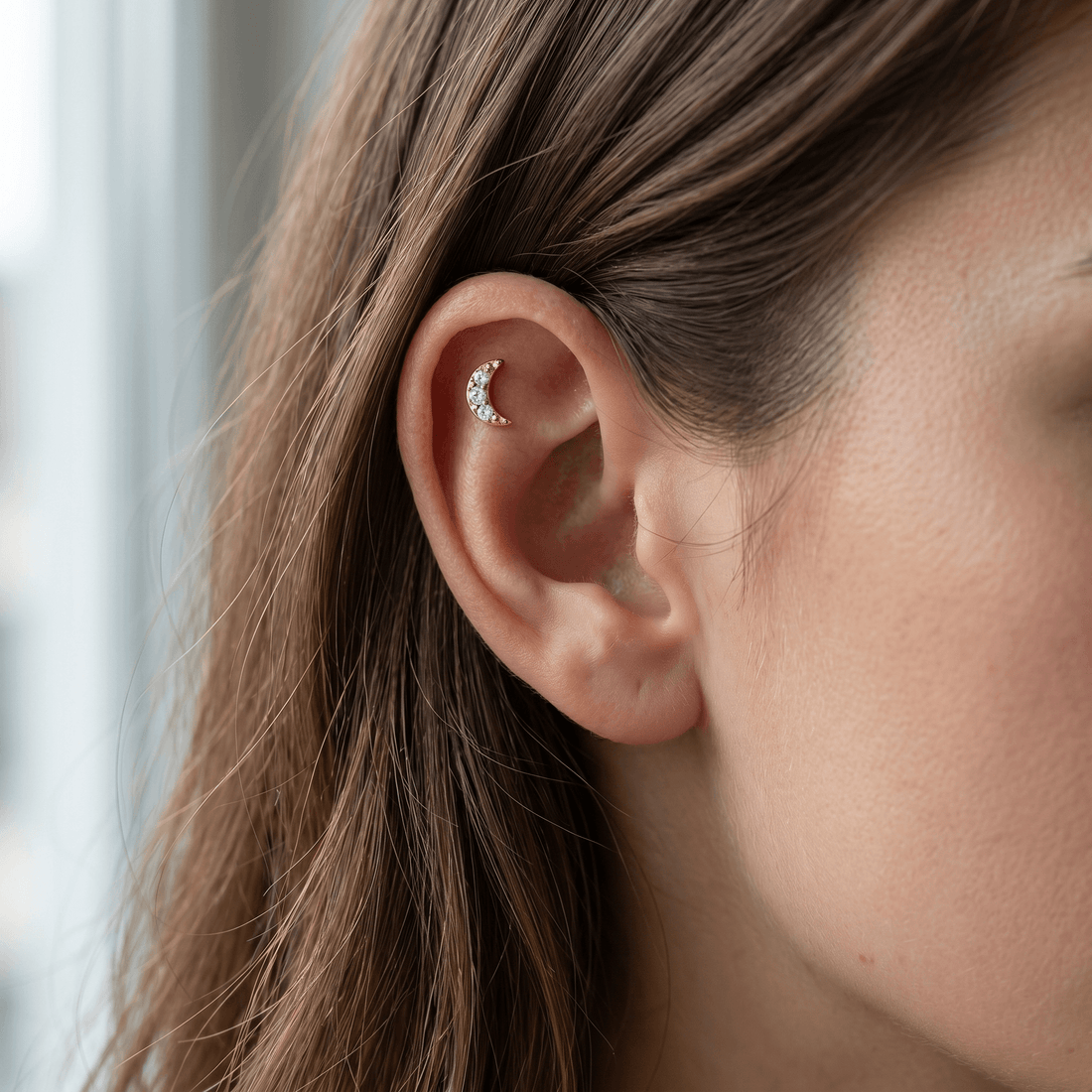 Gold crescent moon zircon stud — flat helix piercing placement