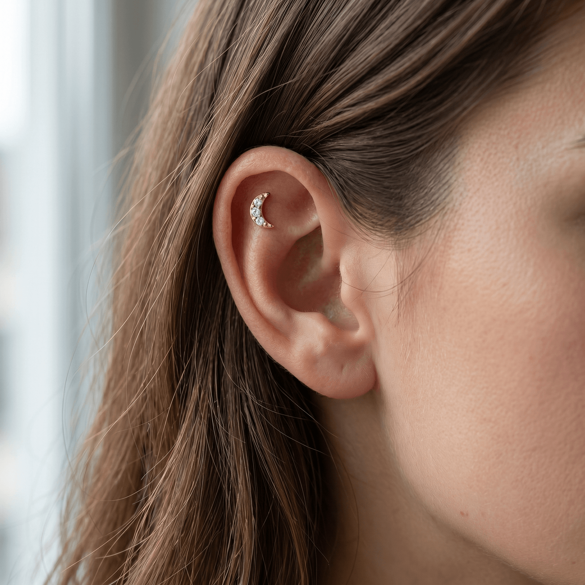 Gold crescent moon zircon stud — flat helix piercing placement