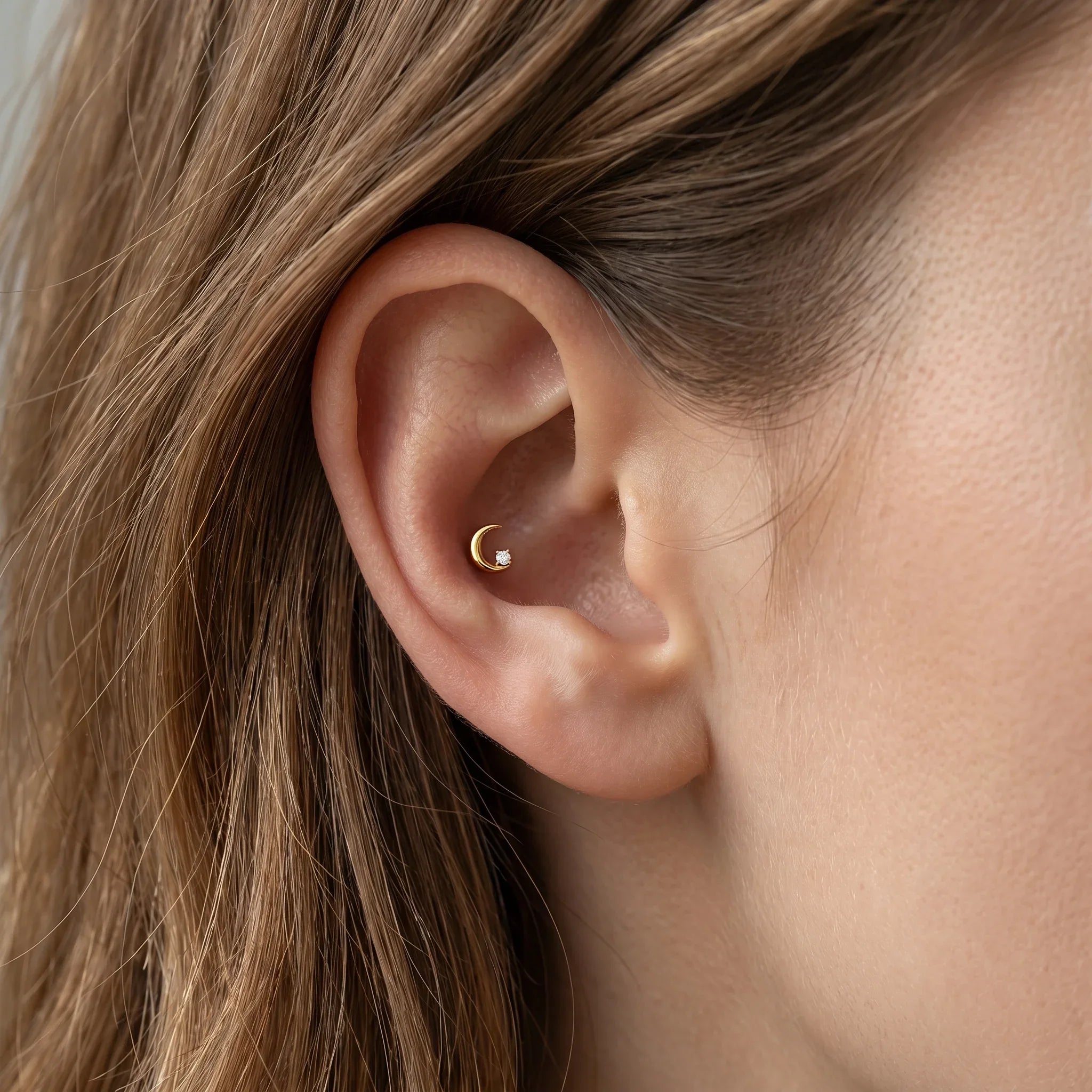 Gold celestial cartilage stud styled in a standard placement.