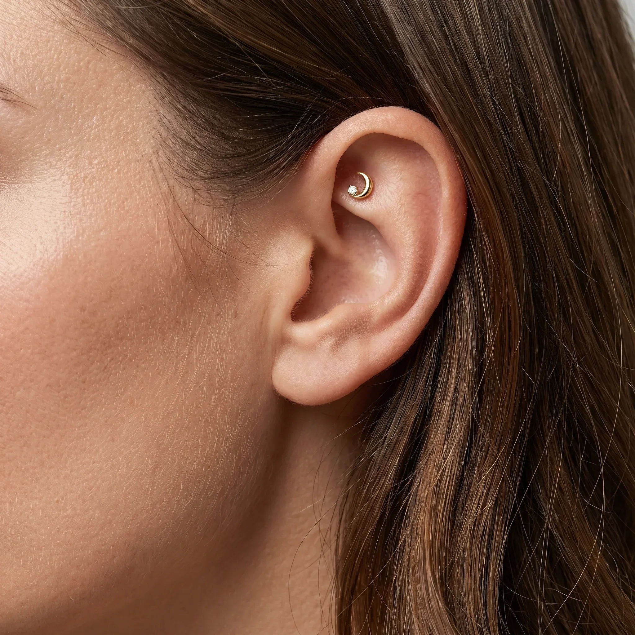 Gold celestial cartilage stud worn elegantly in a faux piercing.
