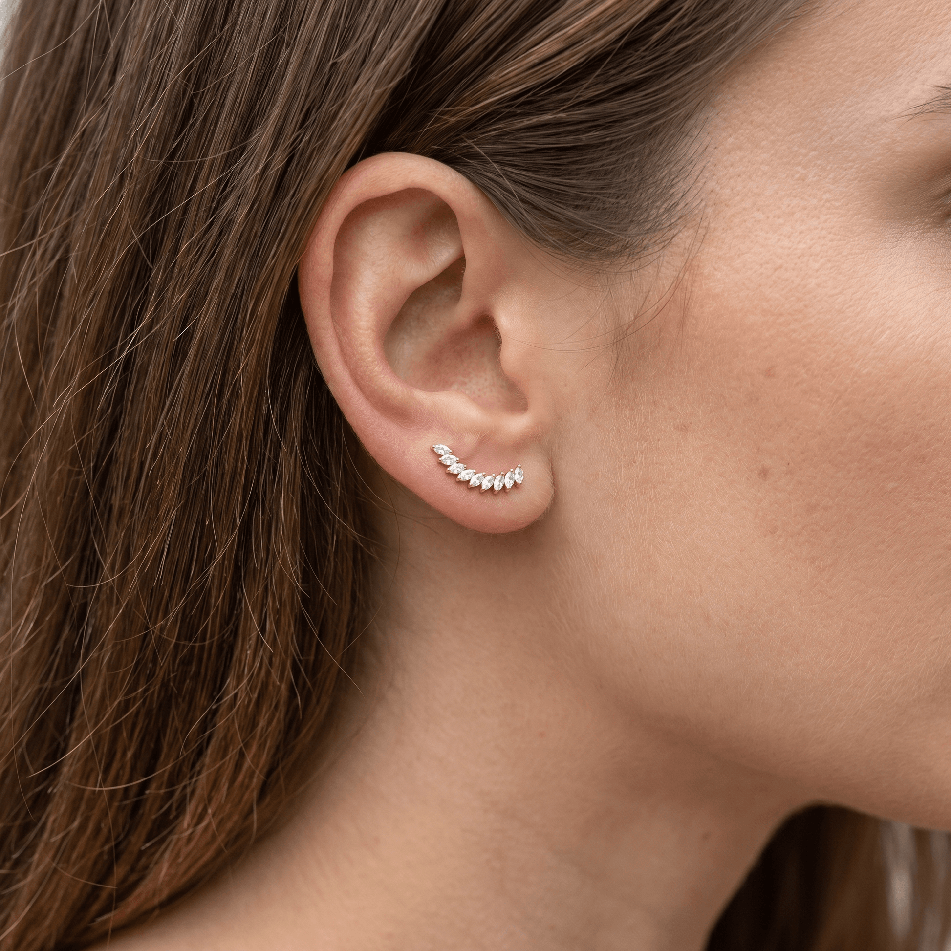 Gold medical-grade titanium stud worn as a stylish ear climber.