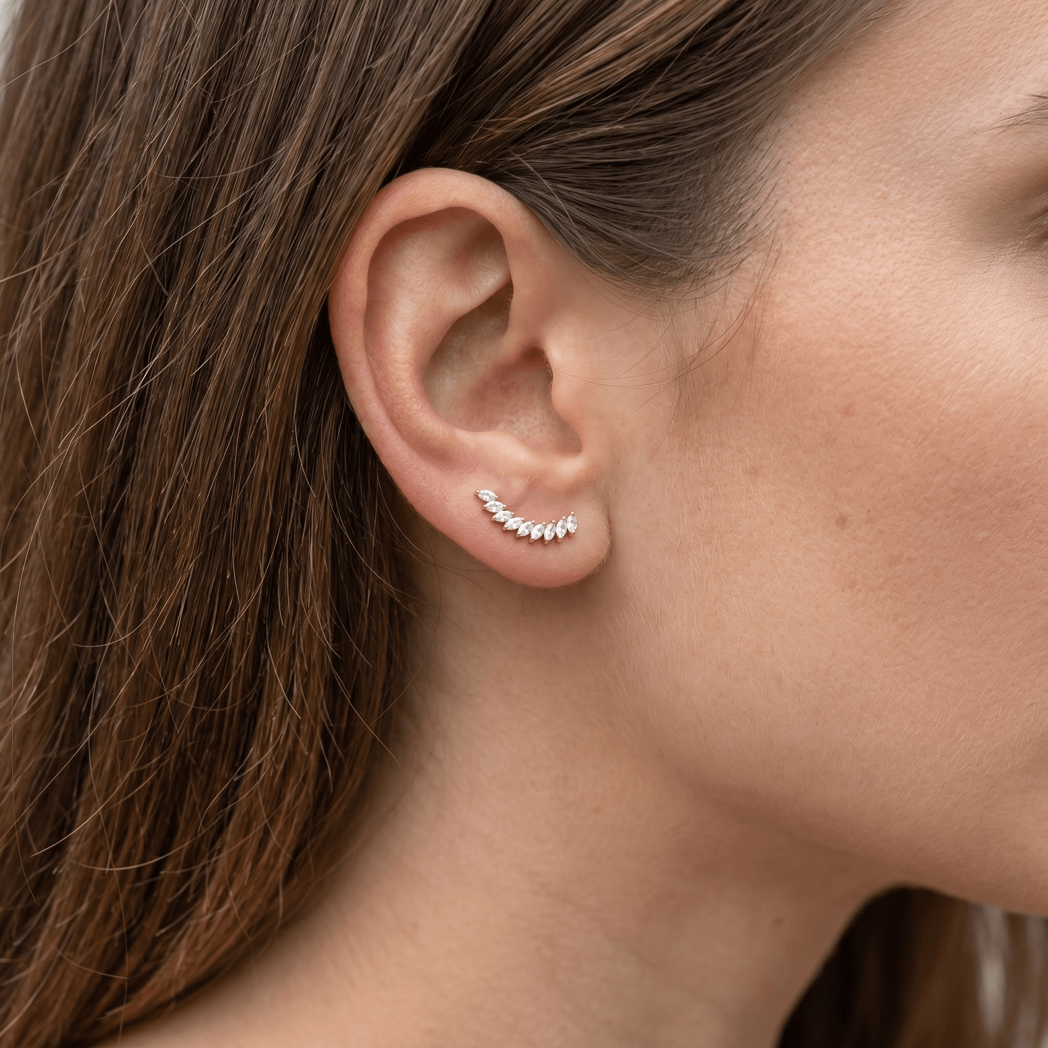 Gold medical-grade titanium stud worn as a stylish ear climber.