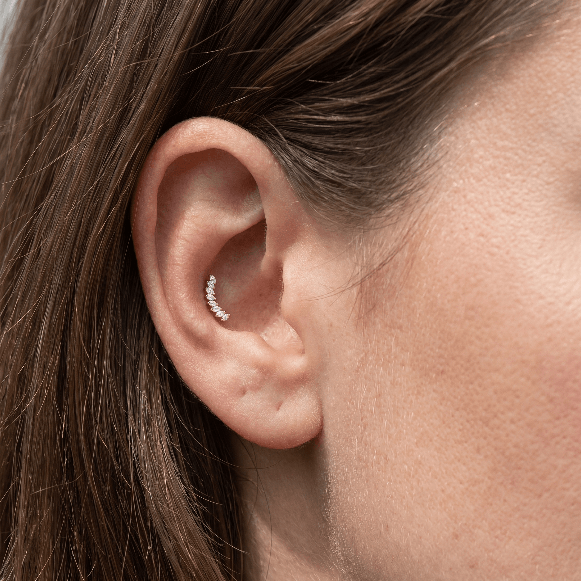 Gold crown leaf outer stud styled in a female ear arrangement.