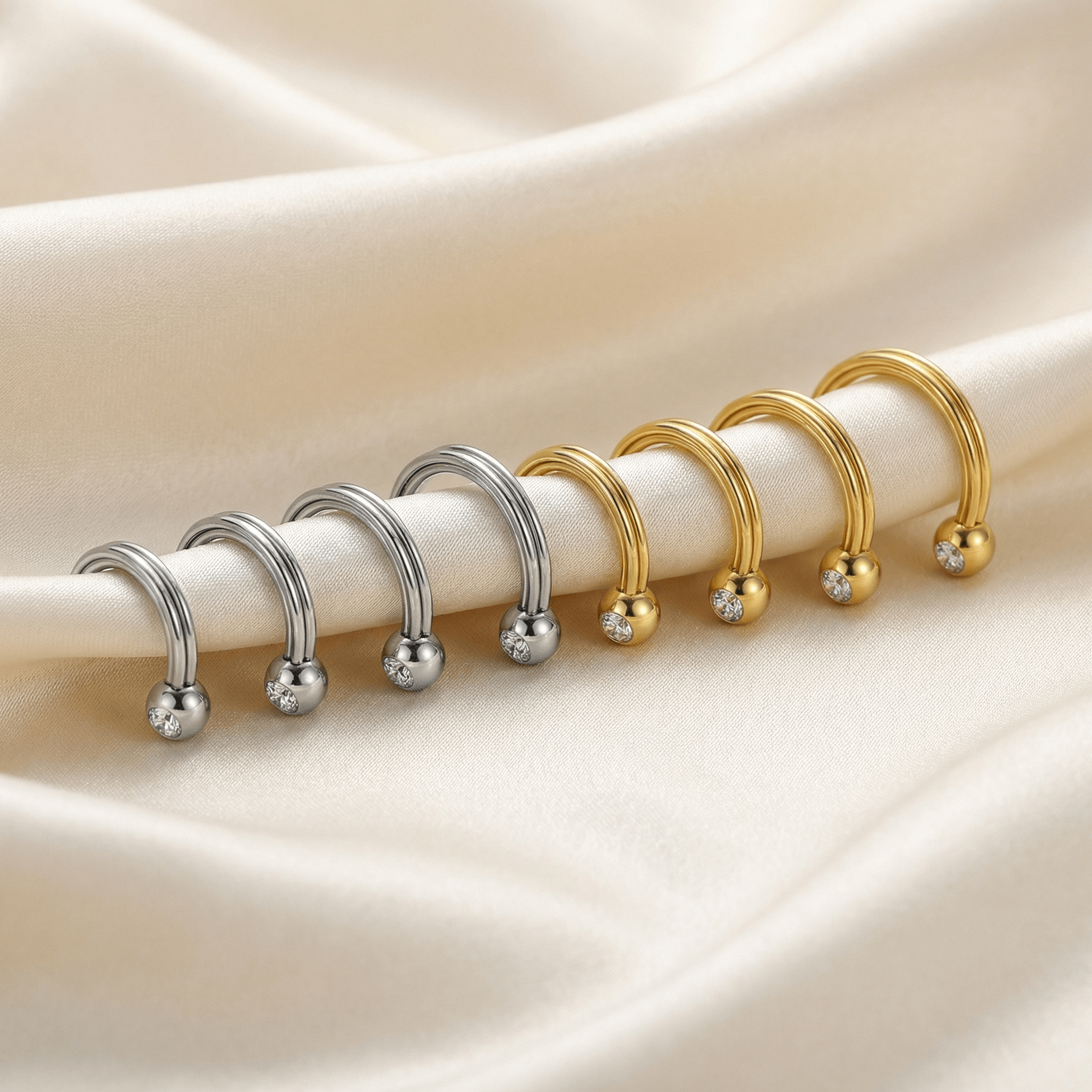 Lineup of silver and gold crystal ball horseshoe rings displayed on a