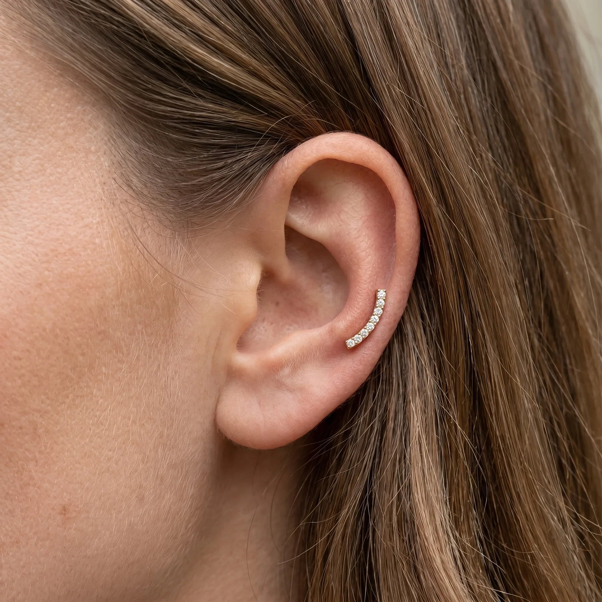 Gold titanium worn in an auricle piercing.