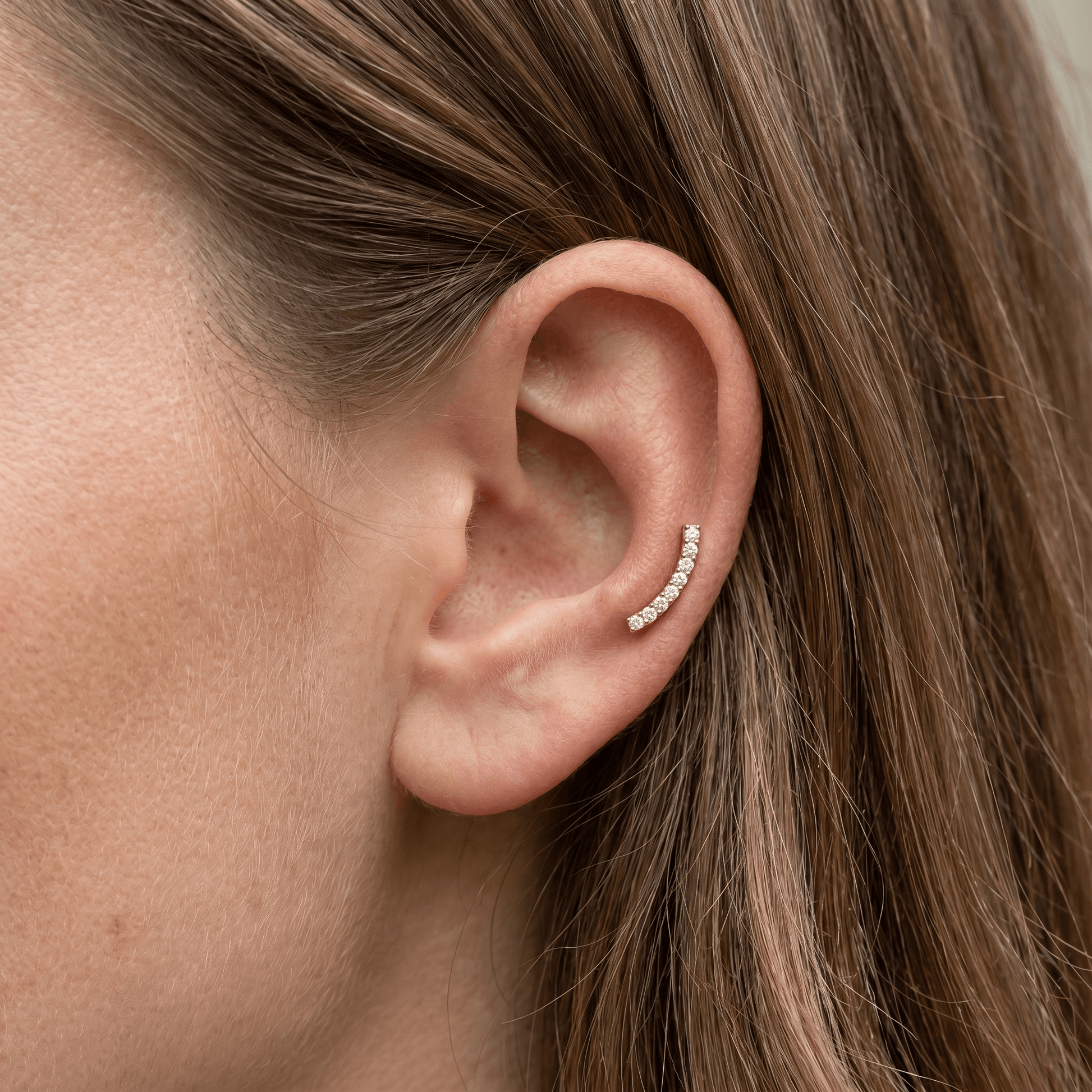 Gold curved bar zircon stud — mid helix piercing placement