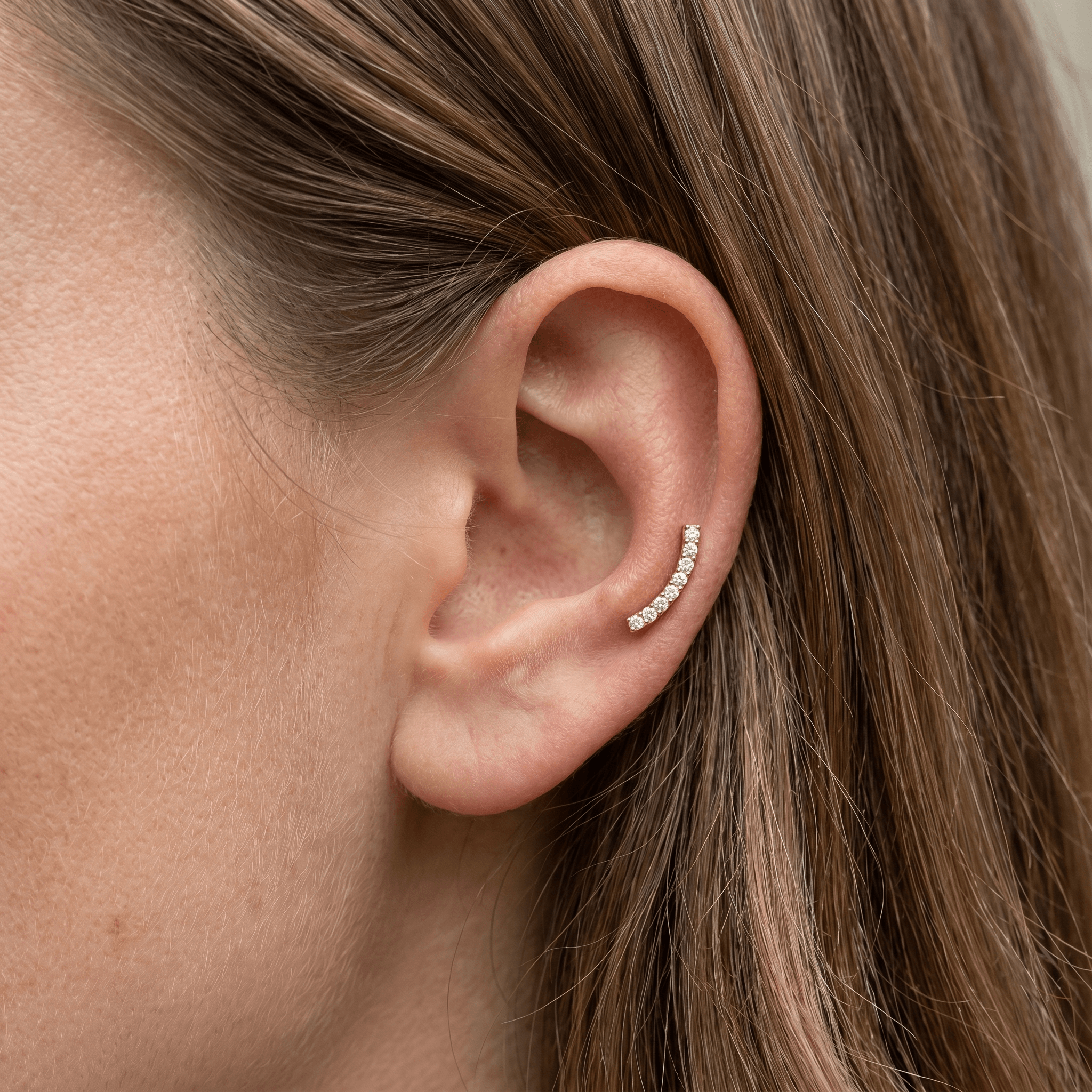 Gold curved bar zircon stud — mid helix piercing placement