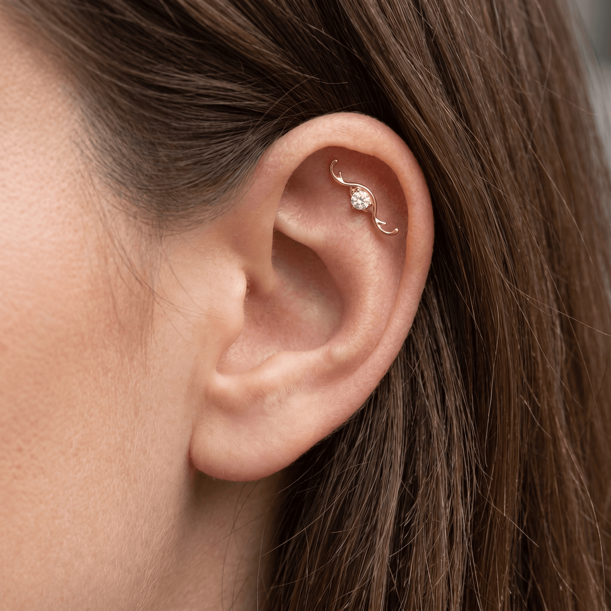 Gold curved wave zircon stud — flat helix piercing placement