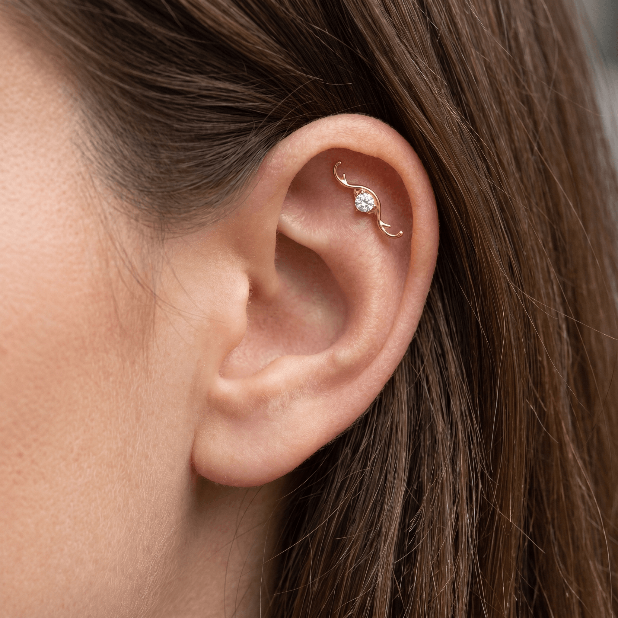 Gold curved wave zircon stud — flat helix piercing placement