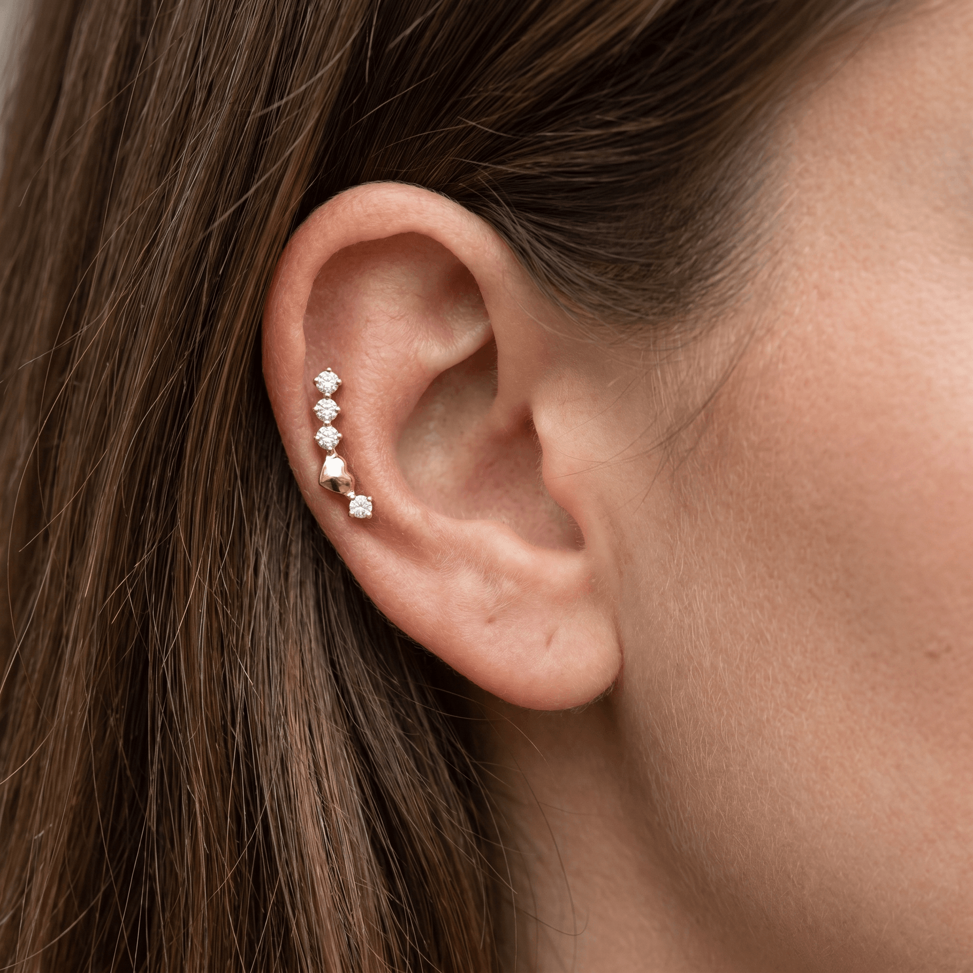 Gold titanium curved zircon piercing stud worn perfectly in a female piercing.