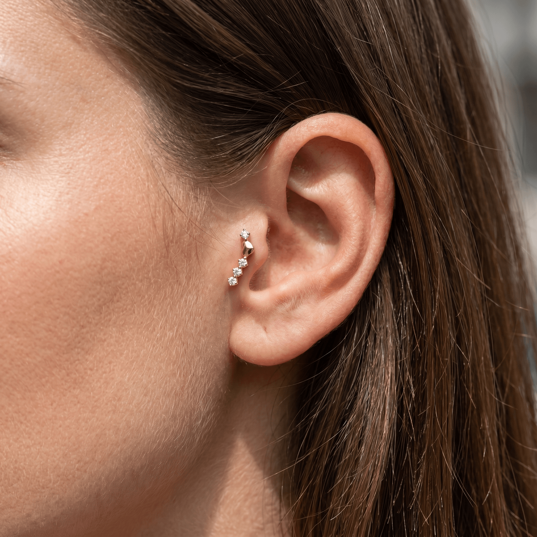 Gold titanium curved zircon piercing stud worn perfectly in a female piercing.