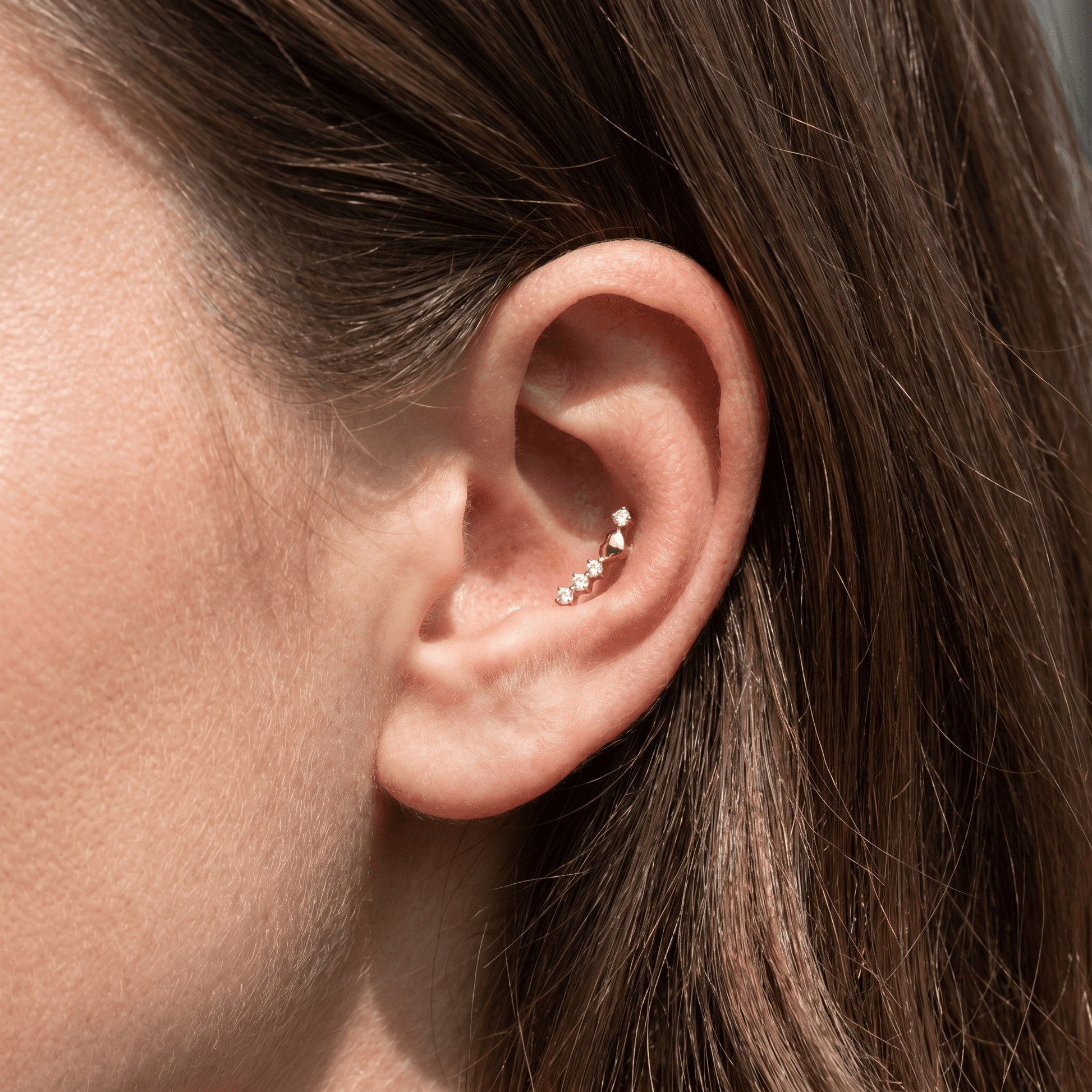 Gold curved zircon stud — conch jewelry placement