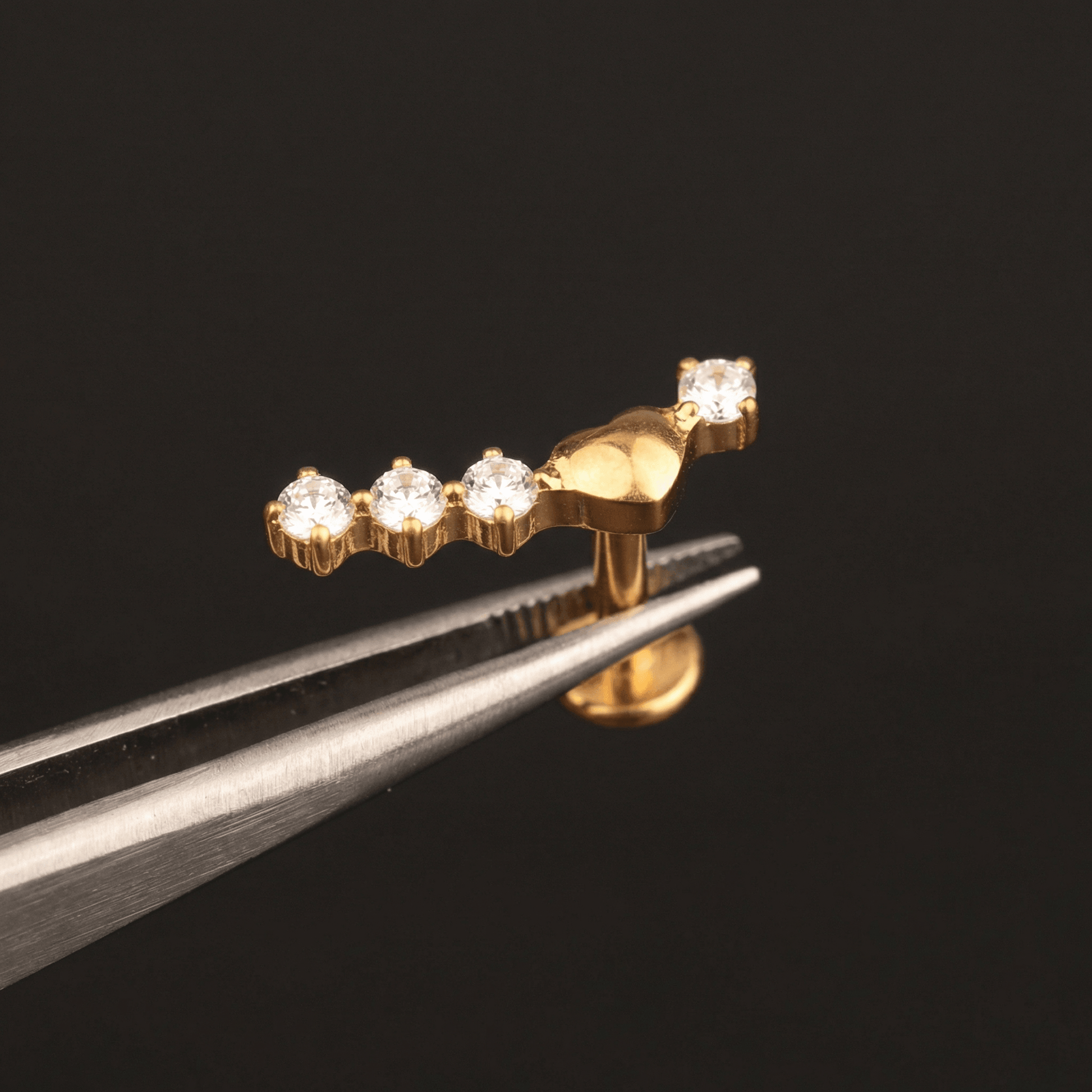 Curved Front Helix Piercing - Tweezers holding a gold