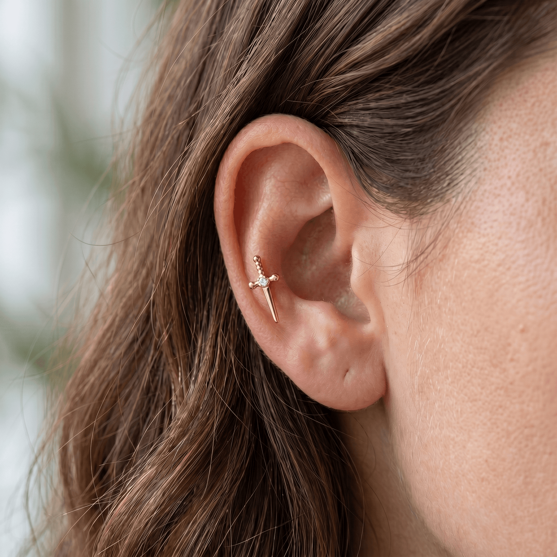 Gold edgy cartilage jewelry styled in a piercing.