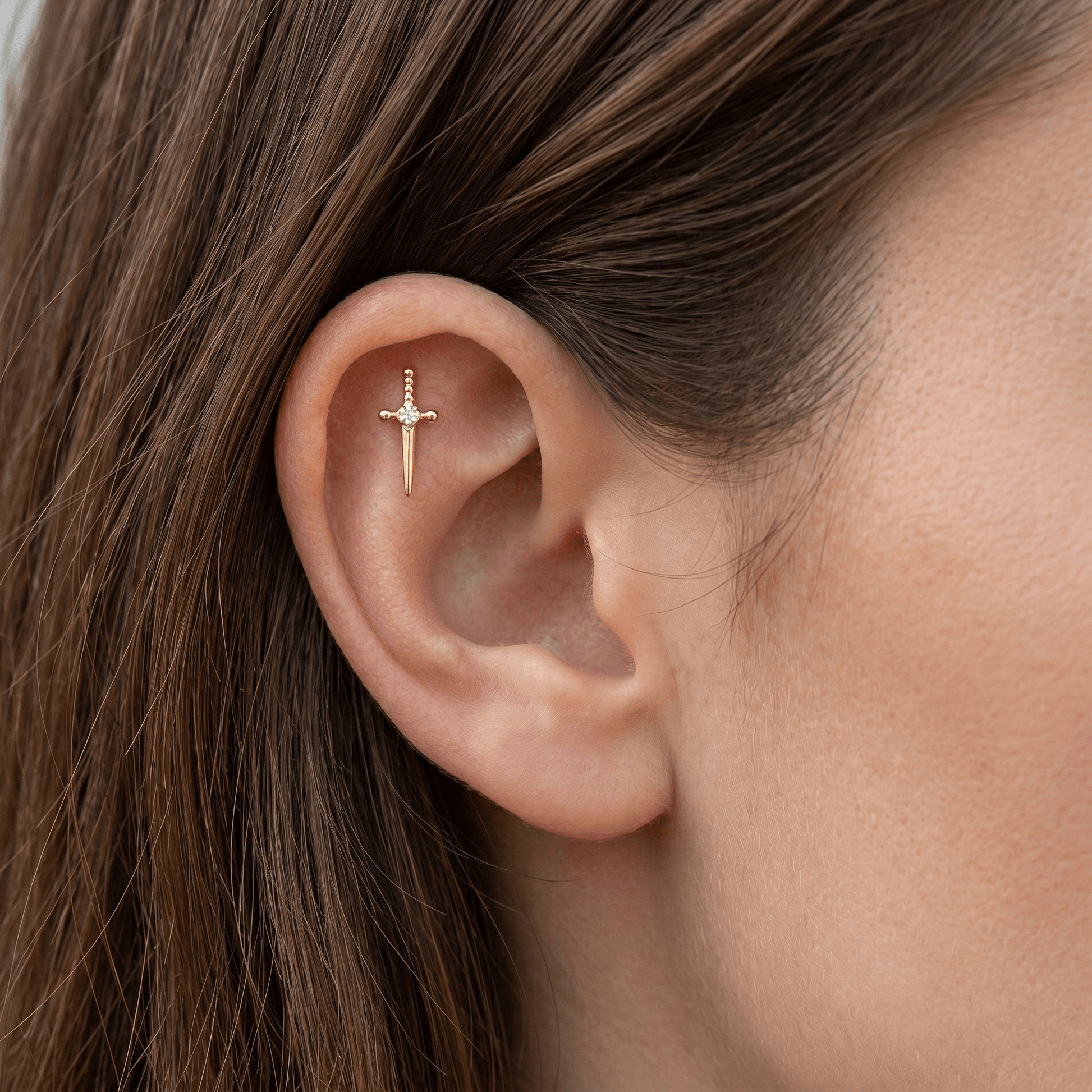 Gold titanium worn elegantly in a piercing.