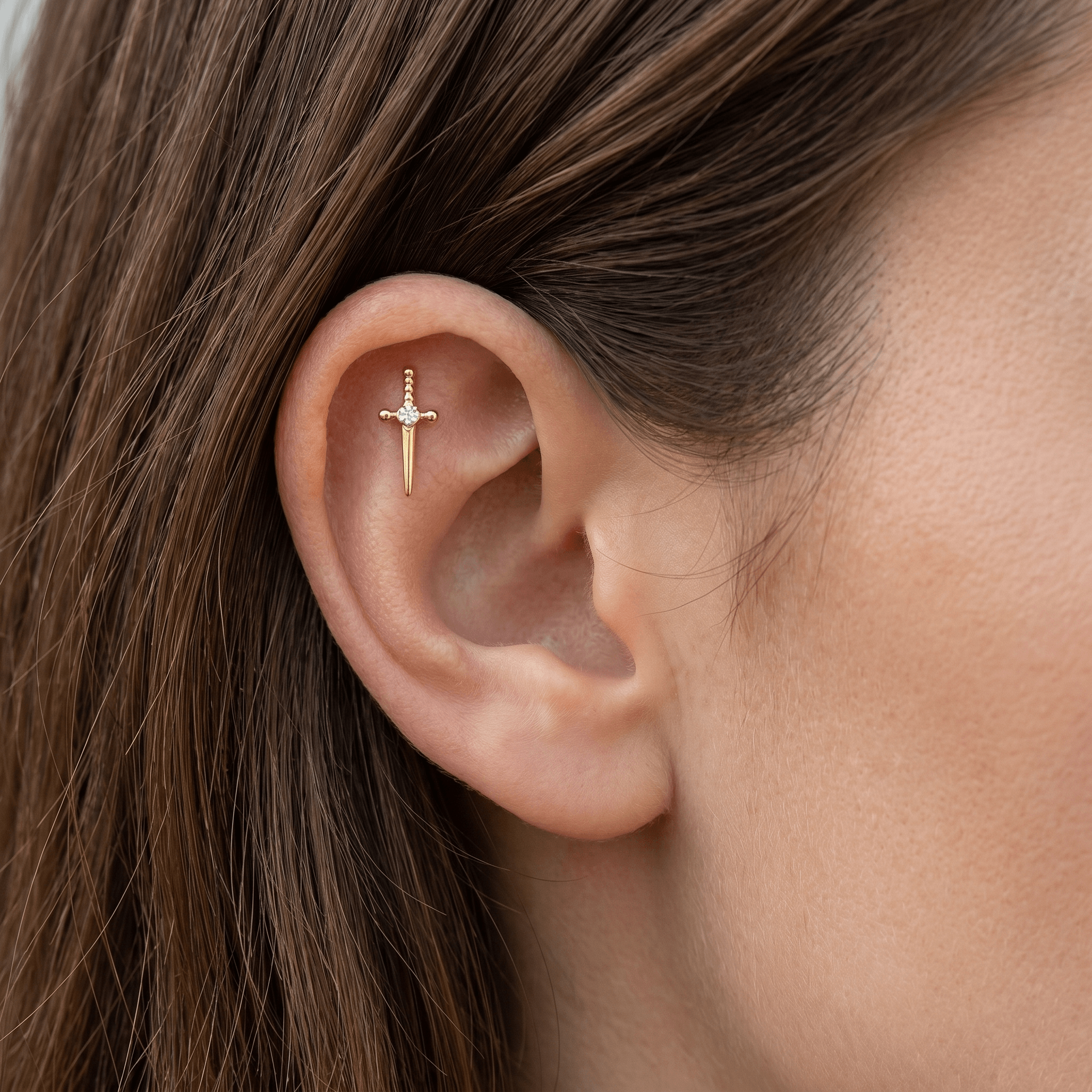 Gold titanium worn elegantly in a piercing.