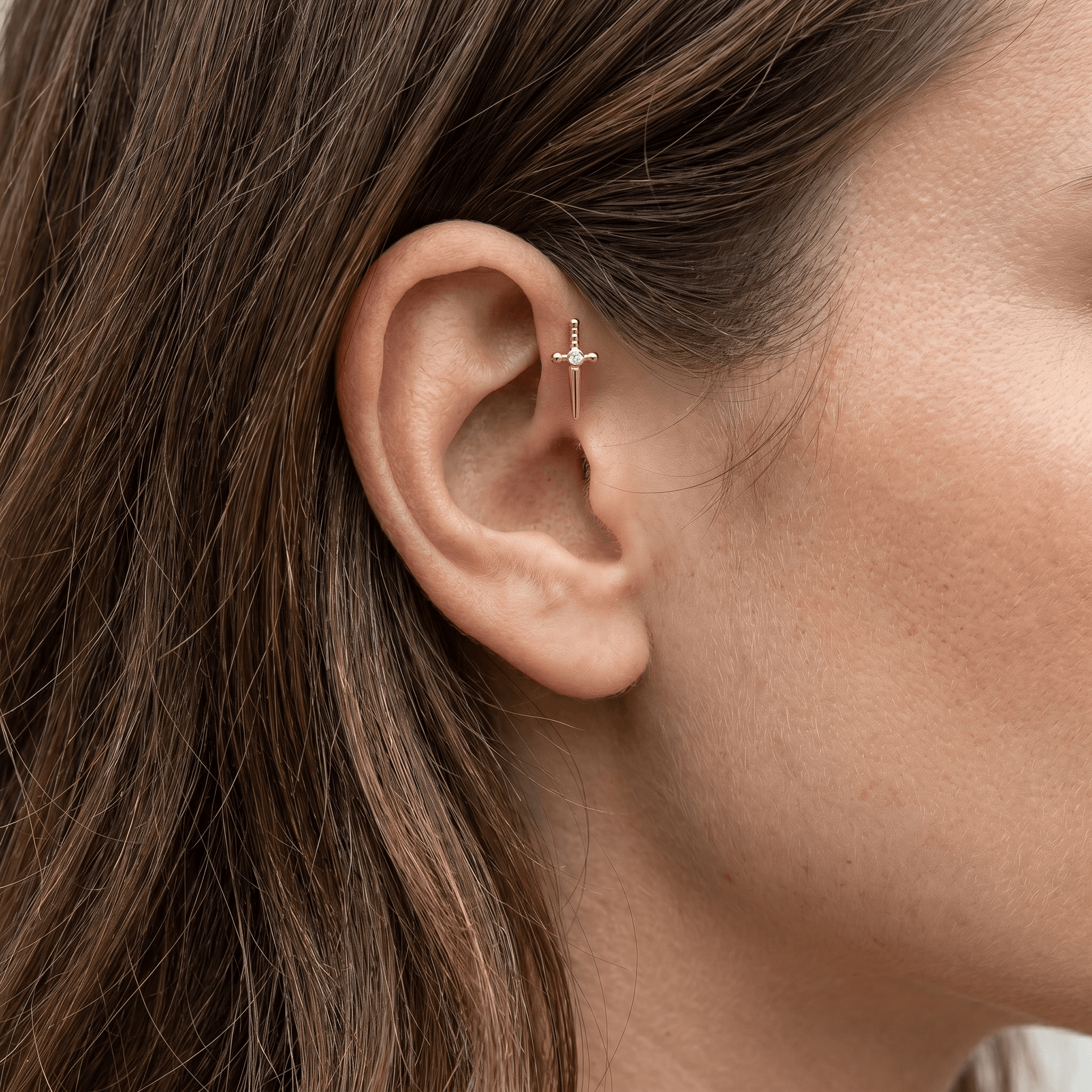 Gold dagger zircon stud — forward helix piercing placement