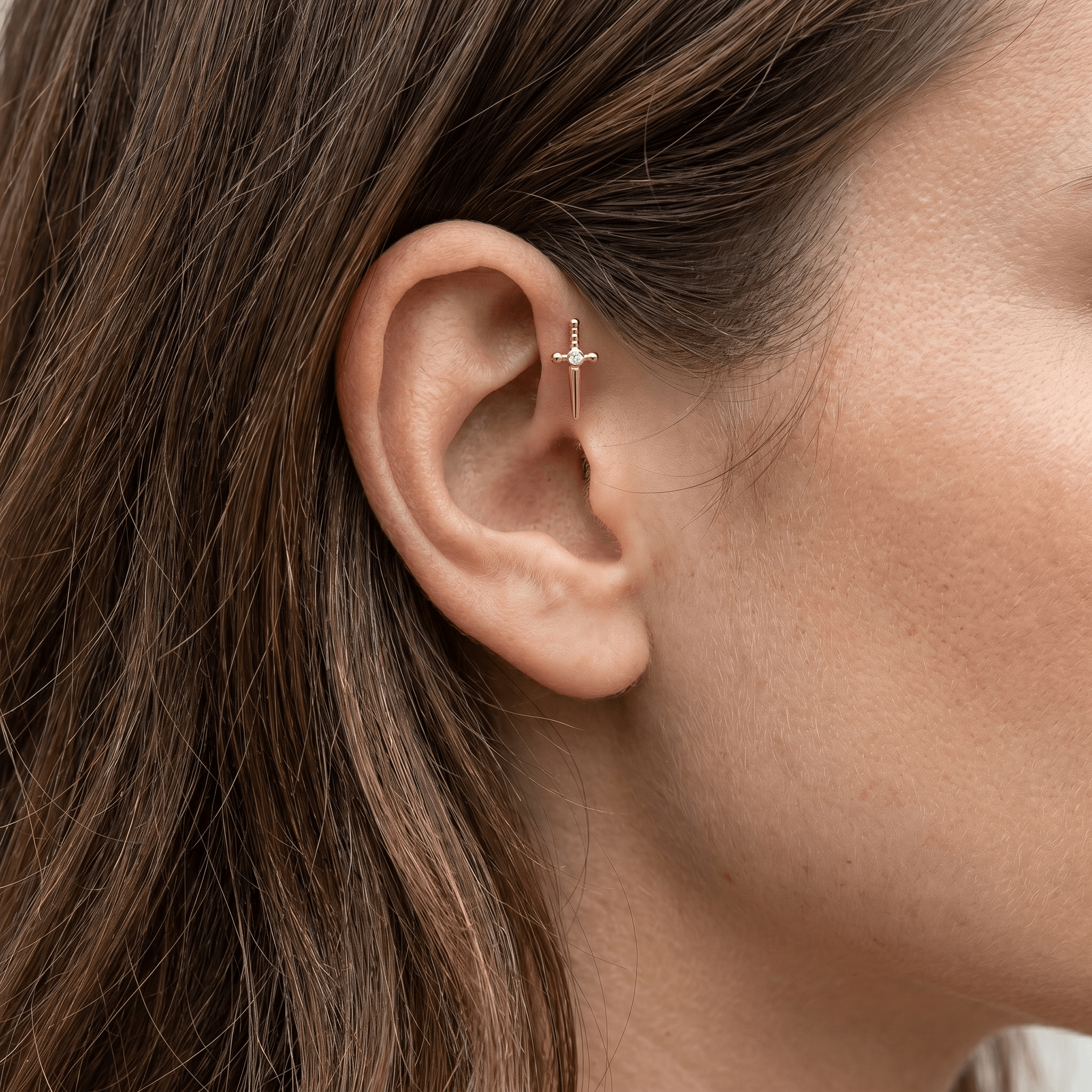 Gold dagger zircon stud — forward helix piercing placement