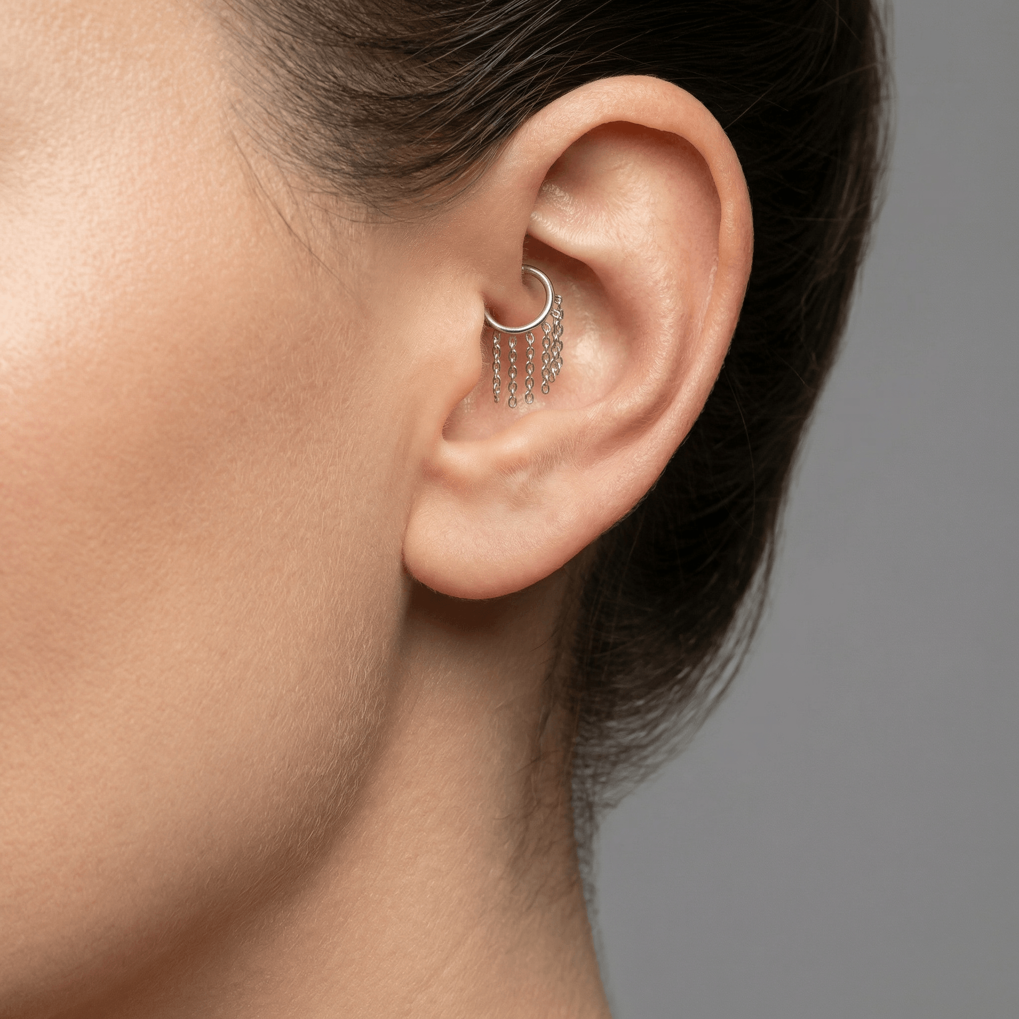 Silver dangling chain clicker ring styled securely in a model's high inner
