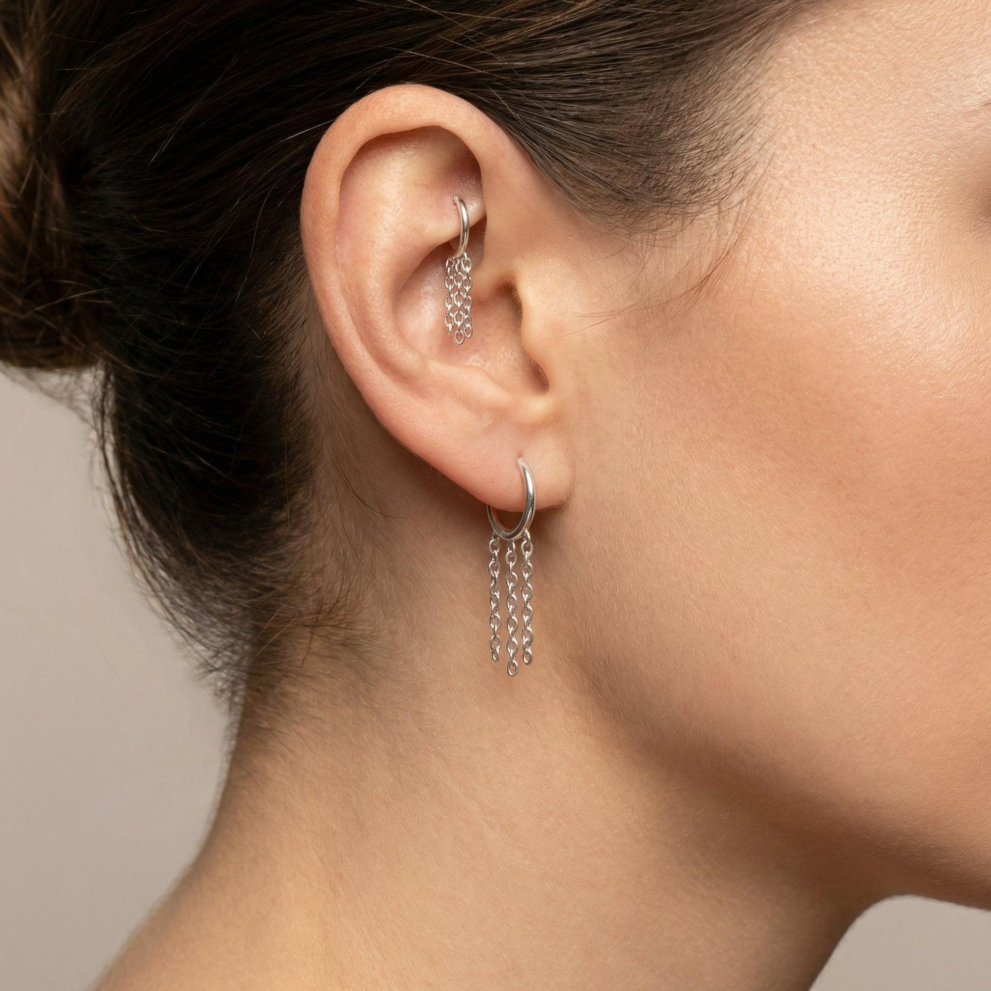 Silver dangling chain clicker jewelry piece worn in a standard lower piercing