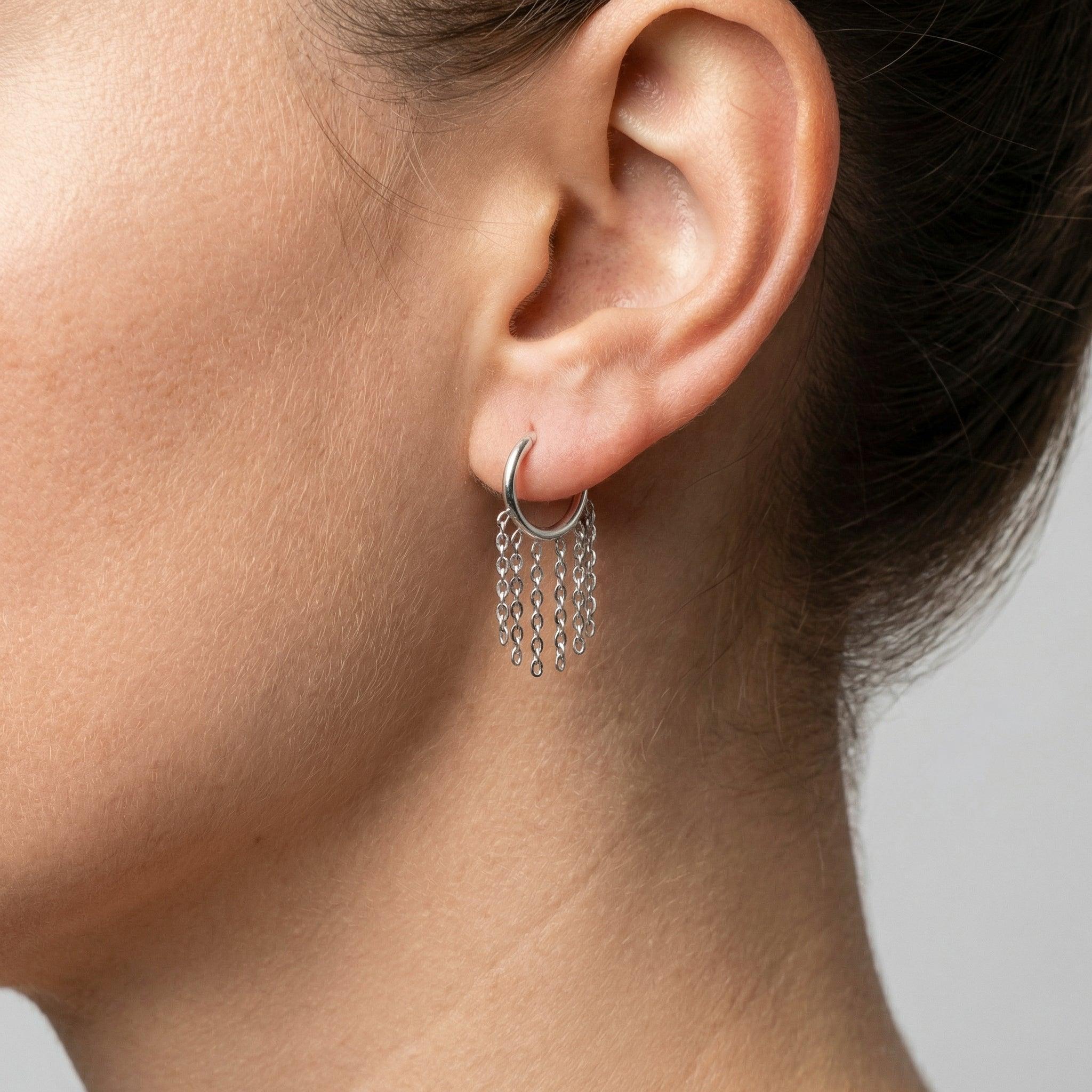 Model showcasing a silver dangling chain clicker ring styled perfectly in a