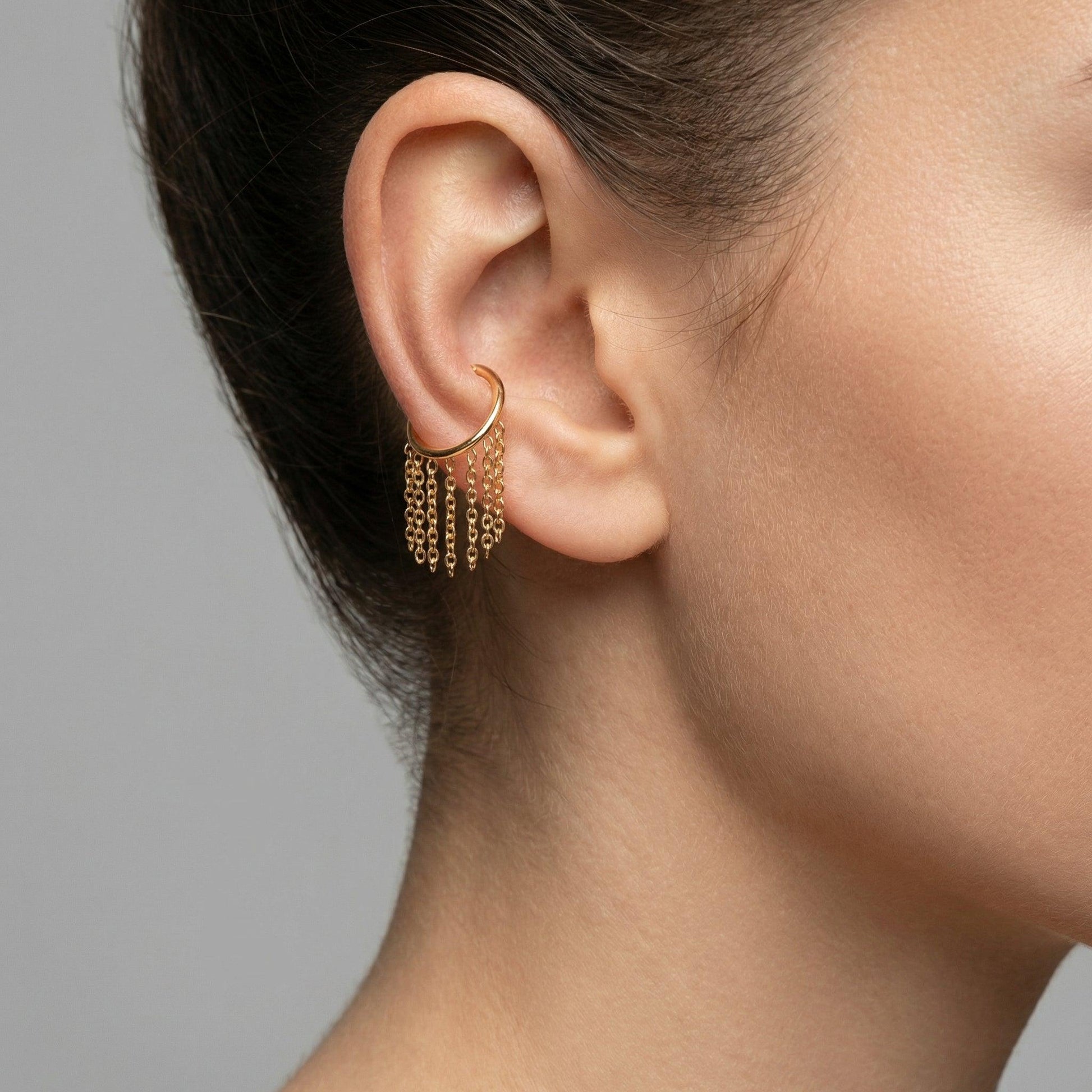 Model wearing a gold dangling chain clicker ring styled neatly inside the