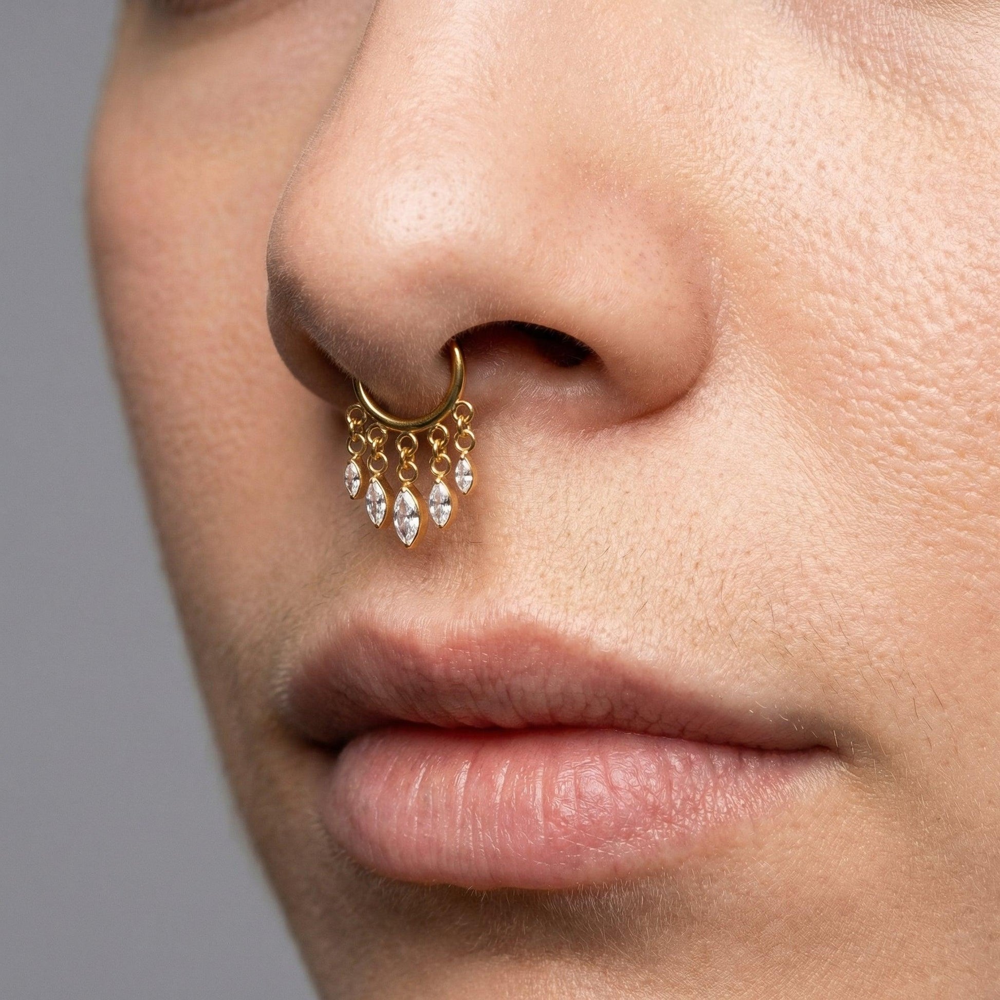 Gold dangling teardrop zircon hinged clicker hoop ring styled seamlessly in a