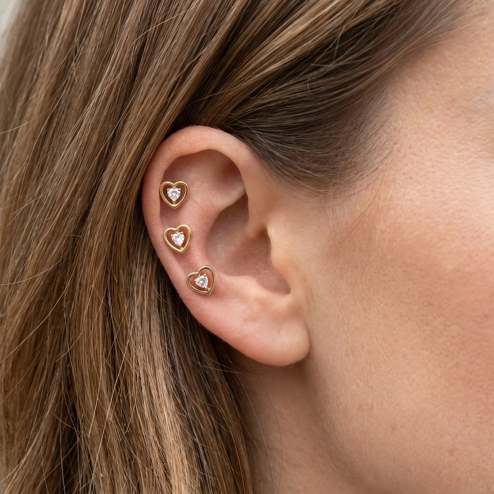 Gold minimalist cartilage jewelry worn in a setup.