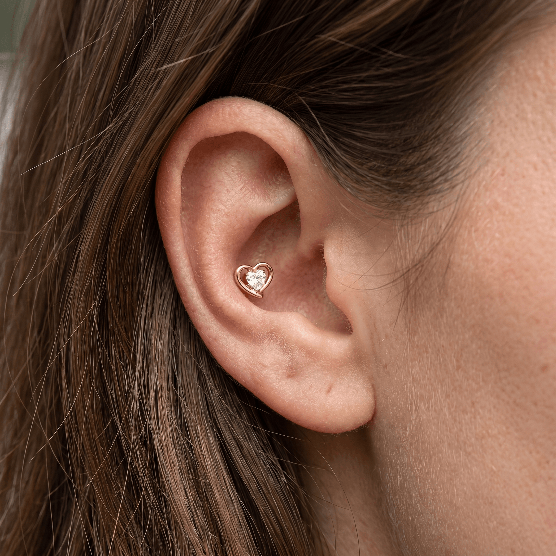 Gold double heart titanium stud worn in a outer piercing.