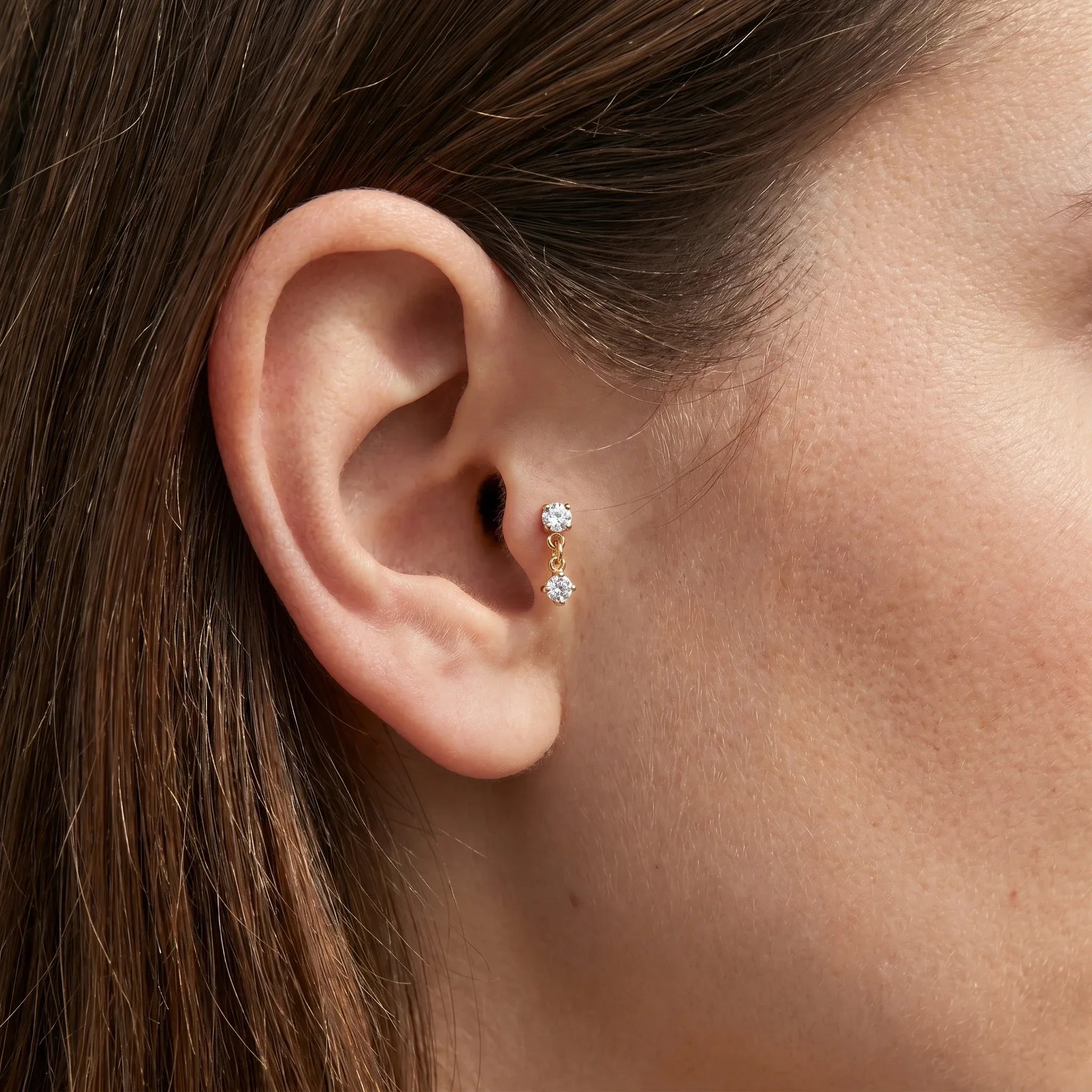 Gold double zircon stud worn in a female ear piercing.