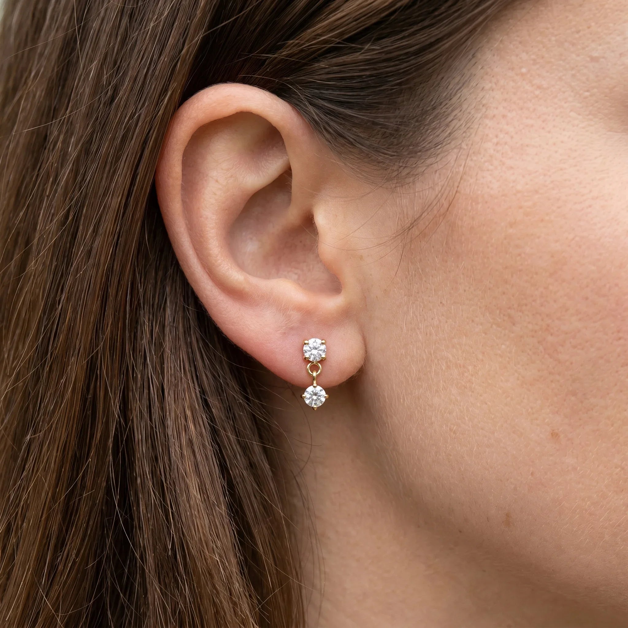 Gold medical-grade titanium stud worn in a standard piercing.