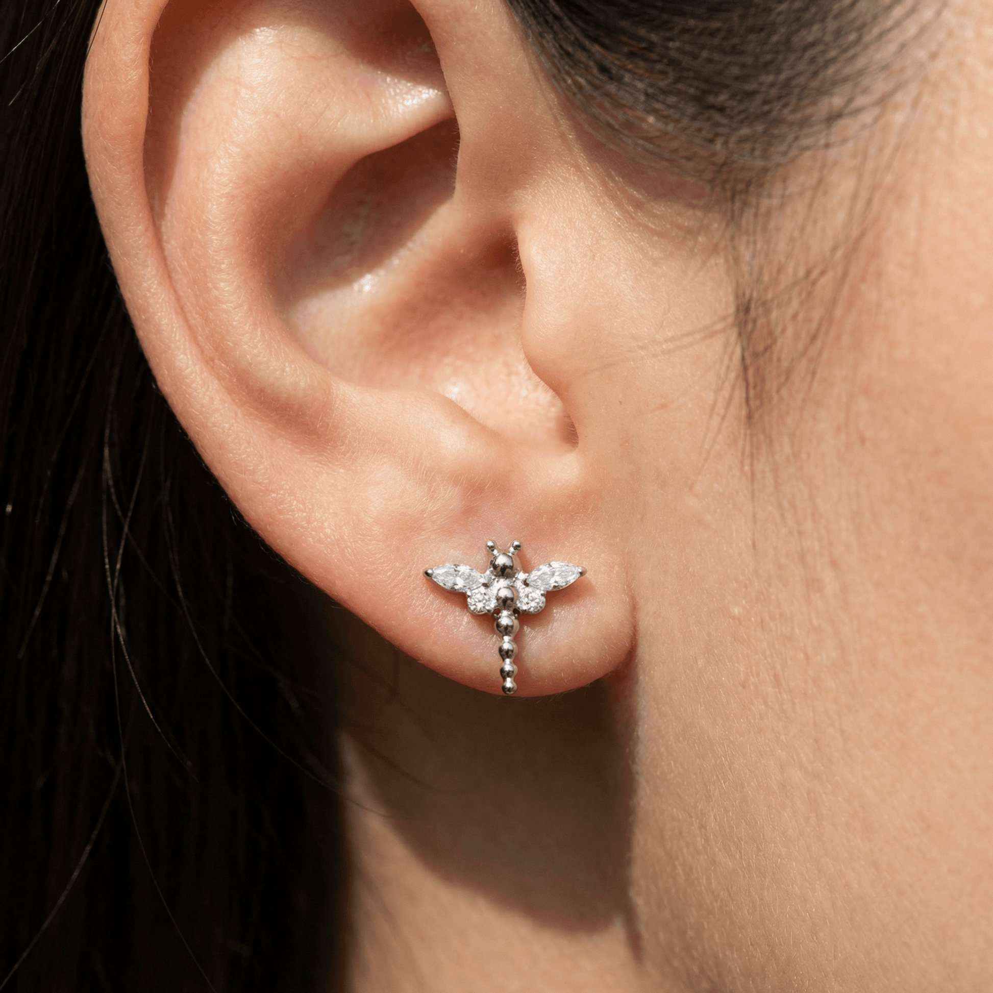 Silver dragonfly ear stud worn in a standard lower piercing.
