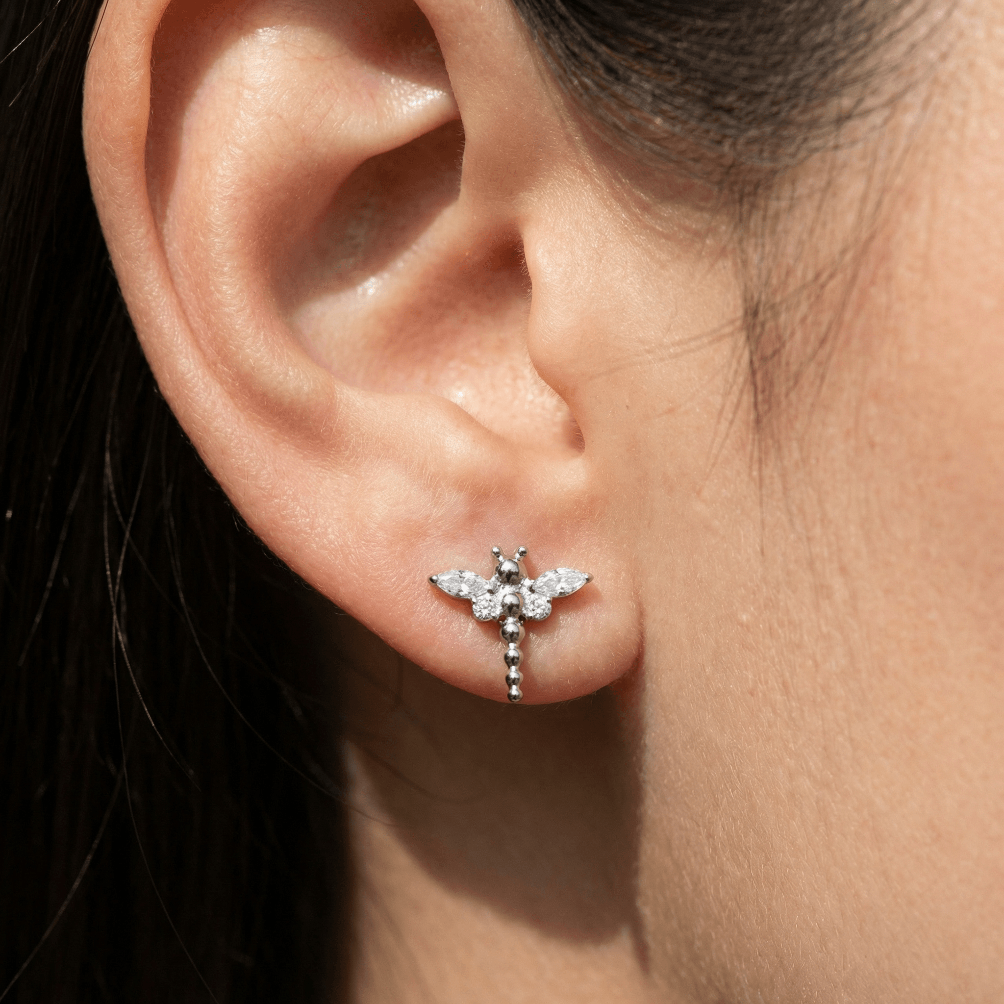 Silver dragonfly ear stud worn in a standard lower piercing.