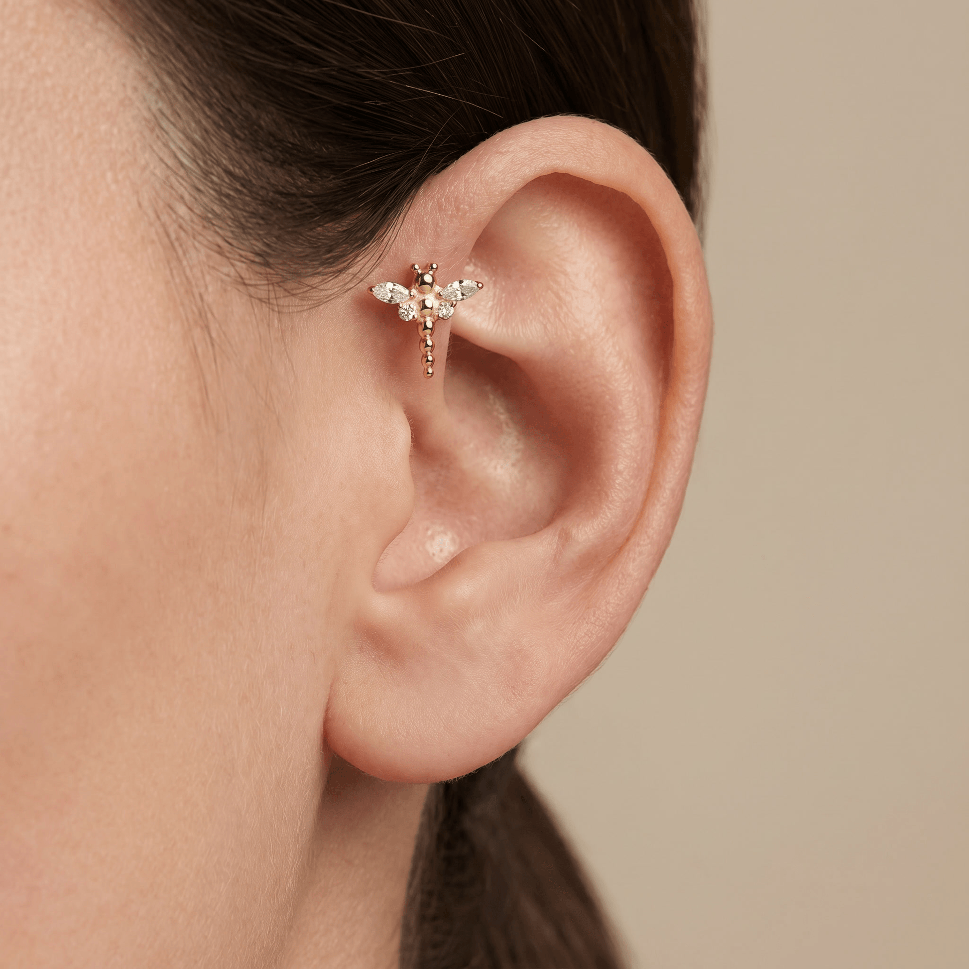 Gold dragonfly stud styled beautifully in a piercing.