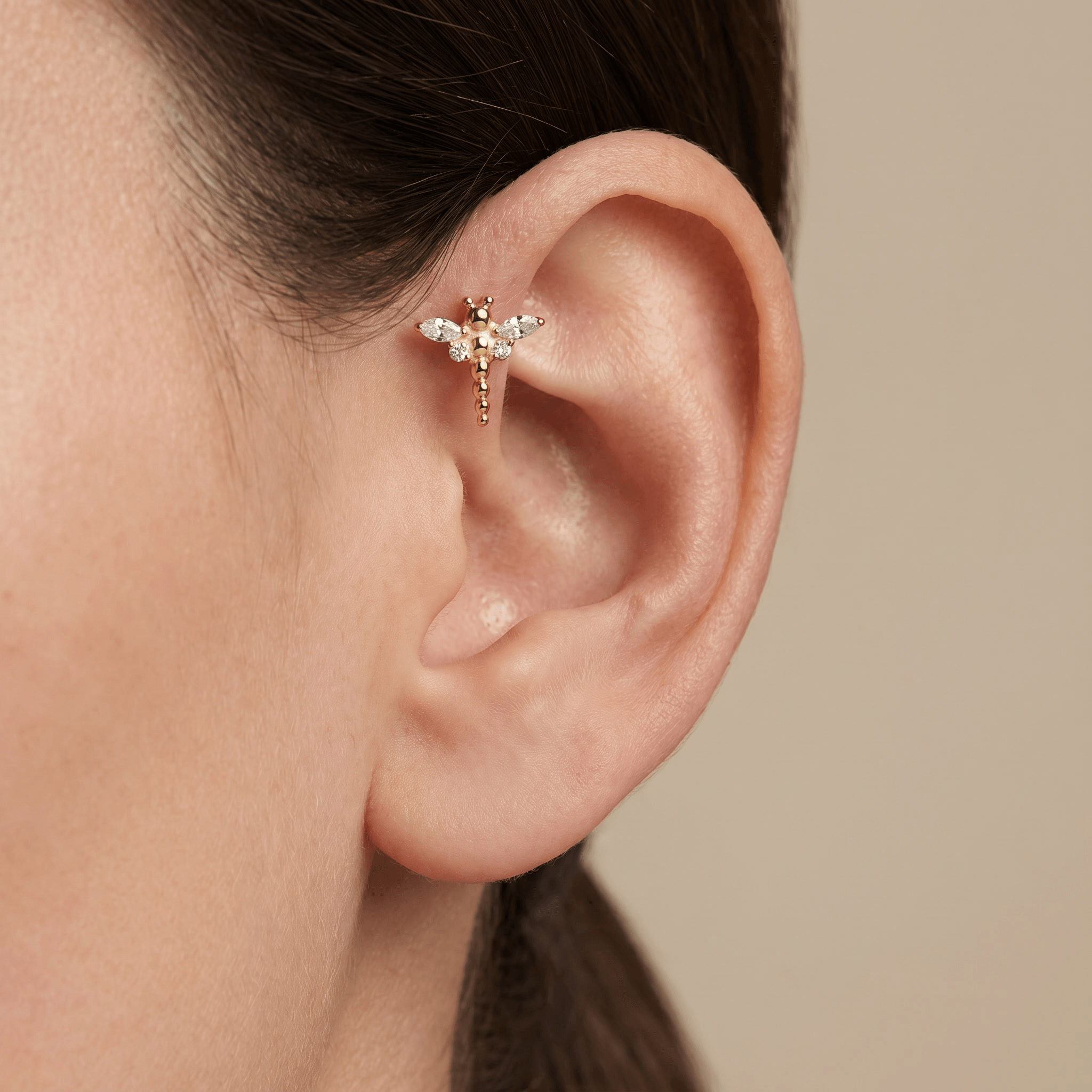 Gold dragonfly stud styled beautifully in a piercing.