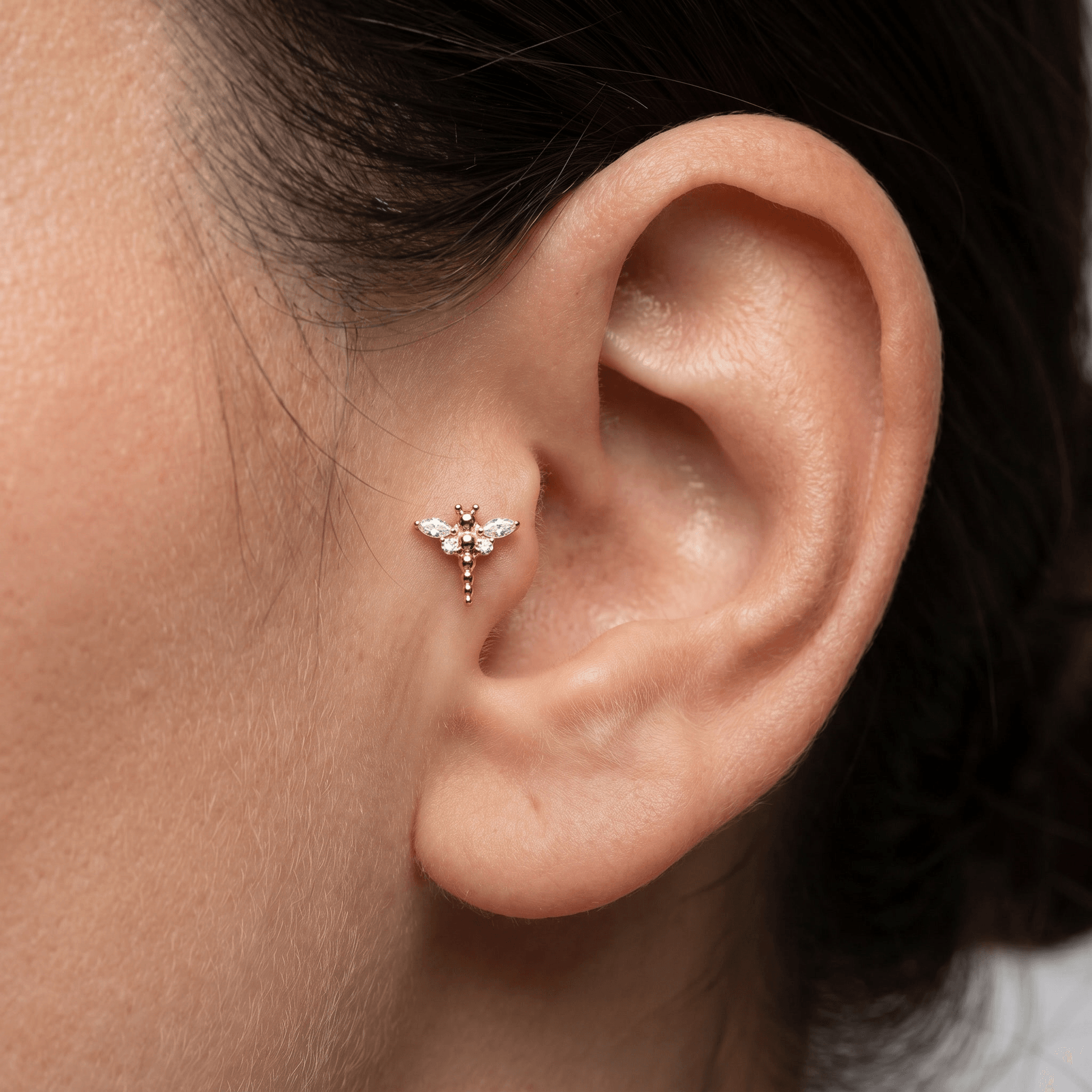 Gold dragonfly piercing jewelry styled as an elegant piercing piece.