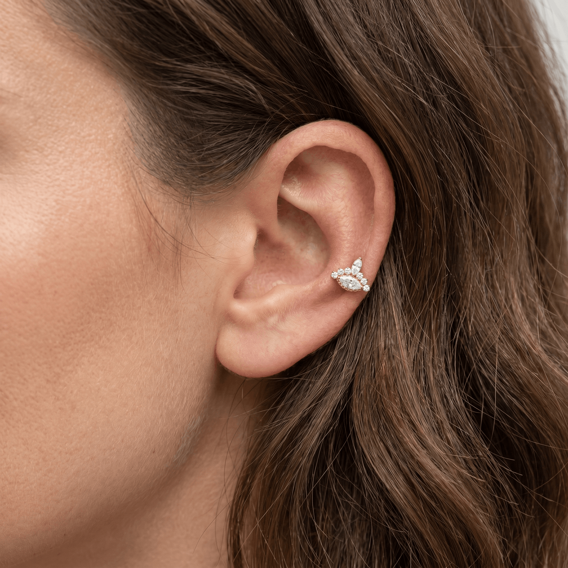 Gold 16g piercing jewelry worn in a cartilage piercing.