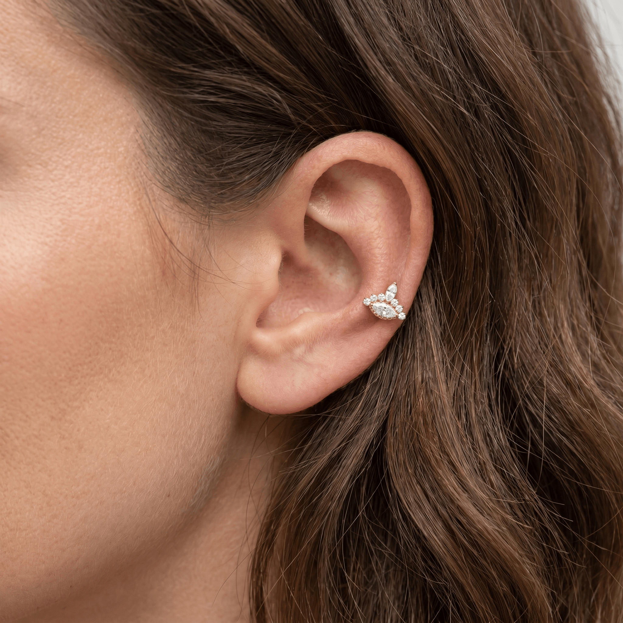 Gold 16g piercing jewelry worn in a cartilage piercing.