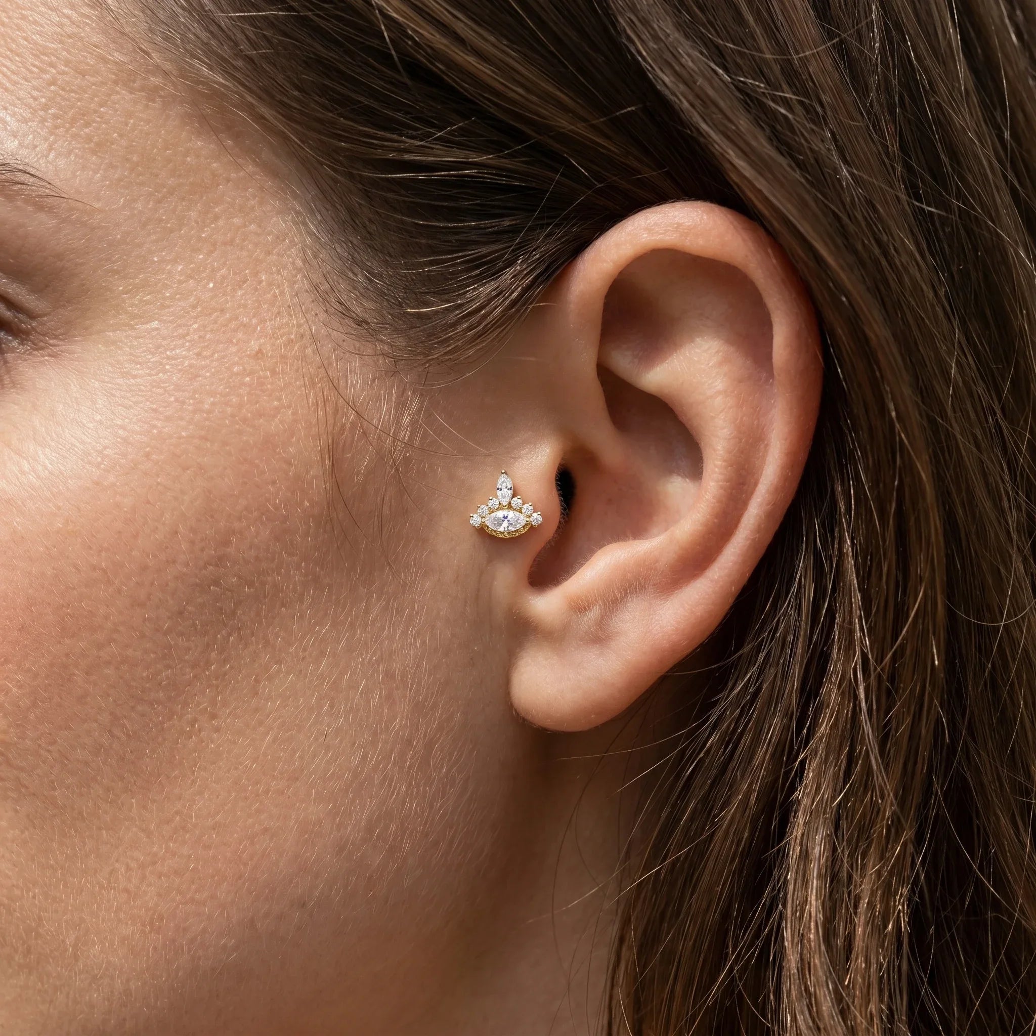 Gold hypoallergenic jewelry styled creatively in a piercing.